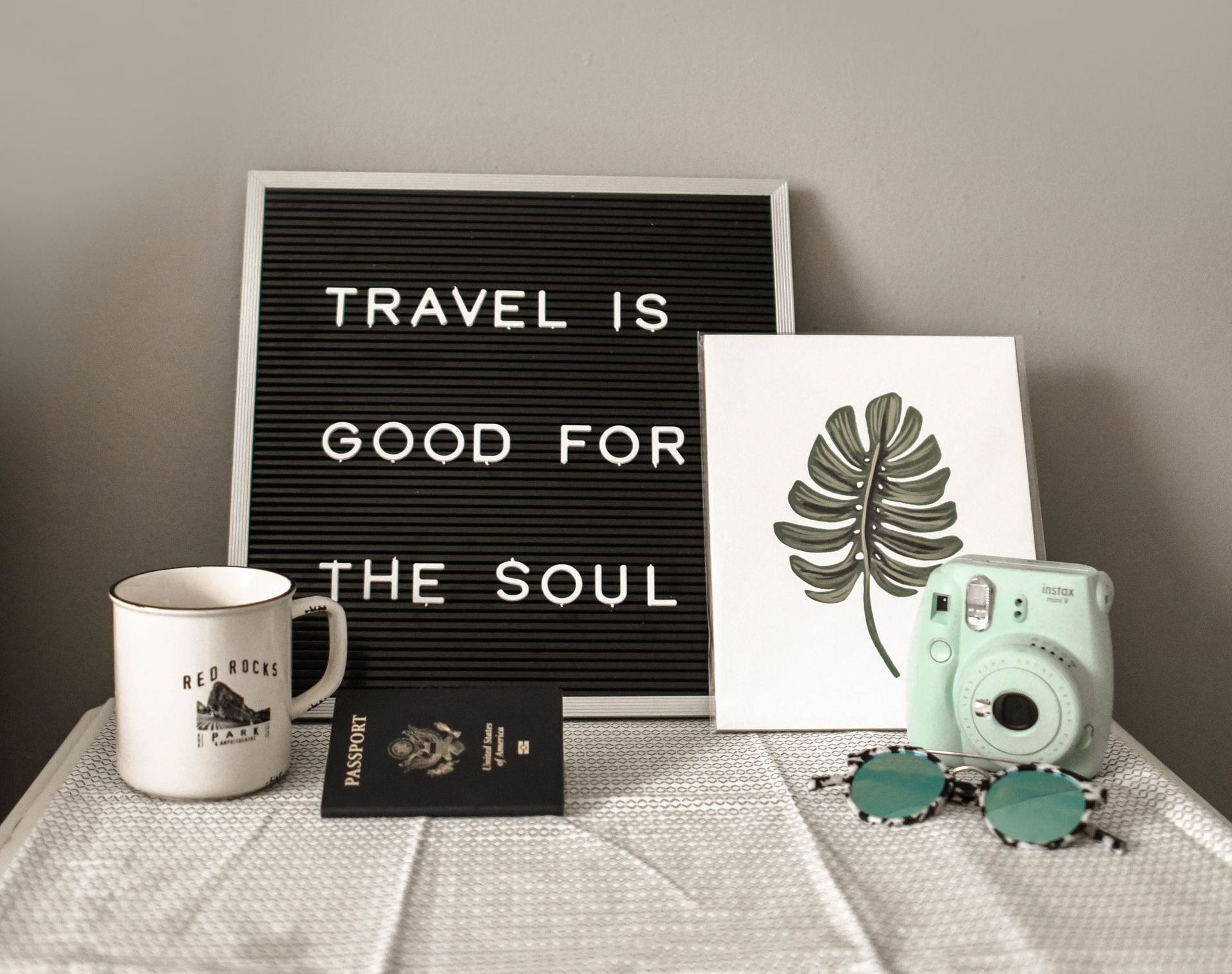 Travel is good for the soul sign, passport, sunglasses.