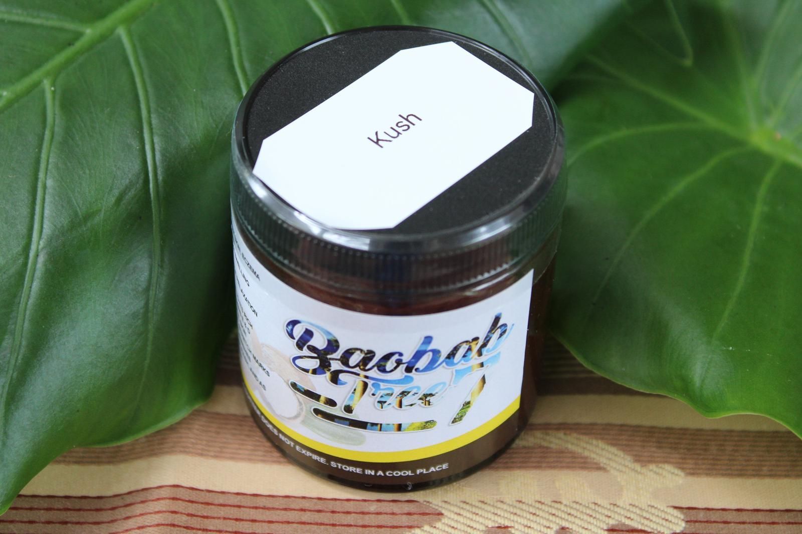 Baobab product jar on a woven mat with green leaves in the background