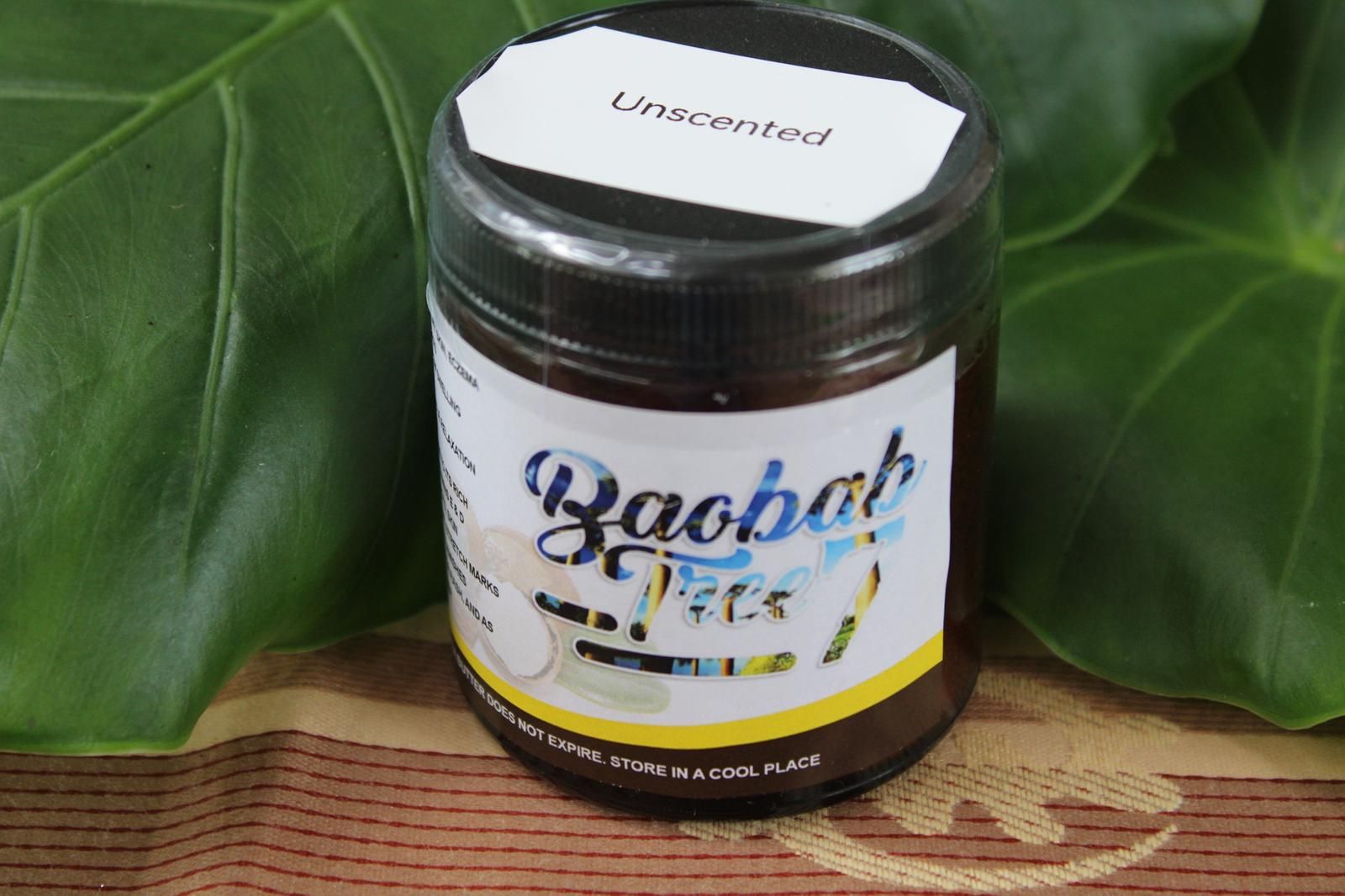 Small black jar labeled “Baobab,” with a white lid, sitting on a leaf backdrop.