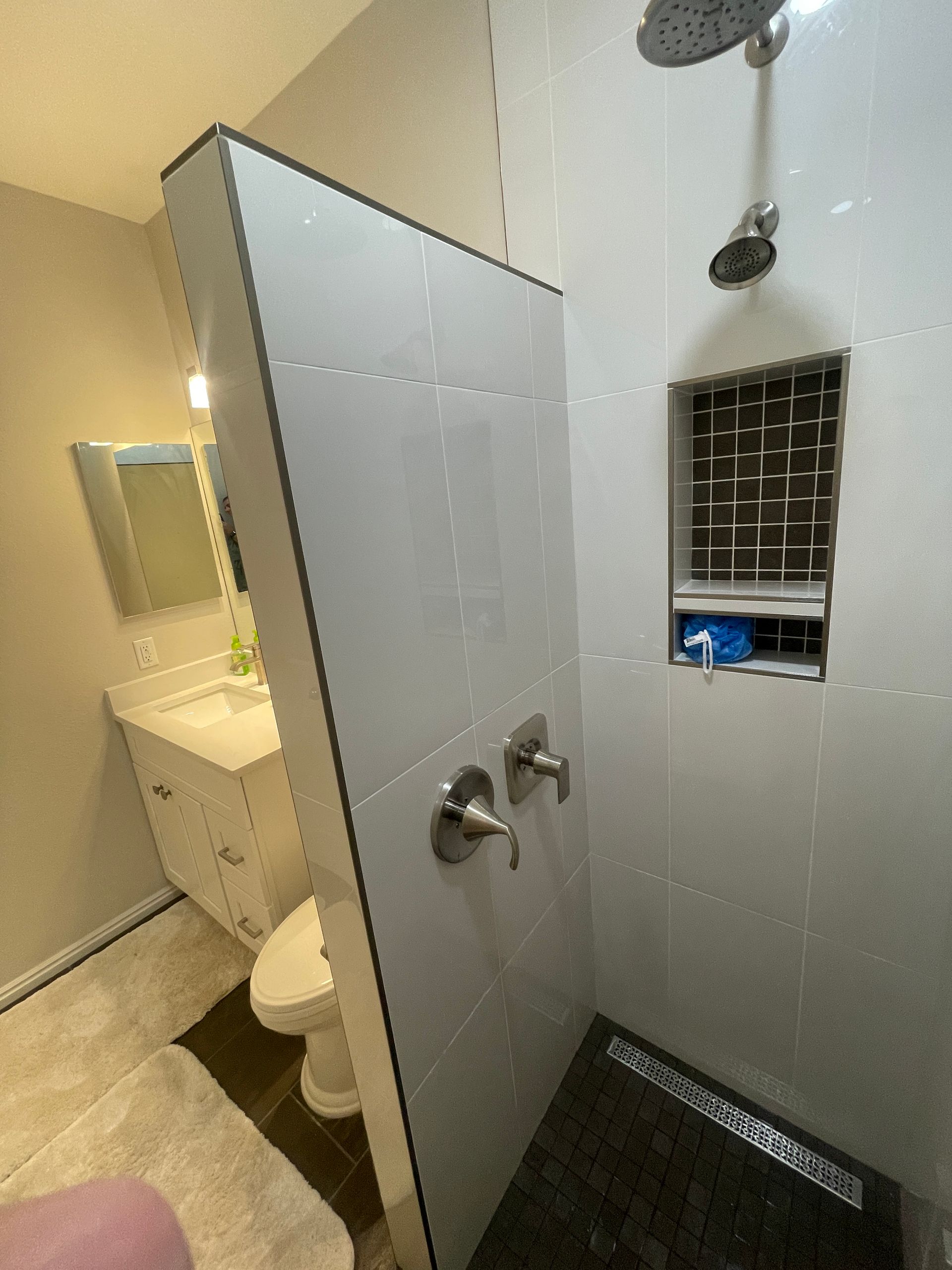 A bathroom with a toilet , sink and shower.
