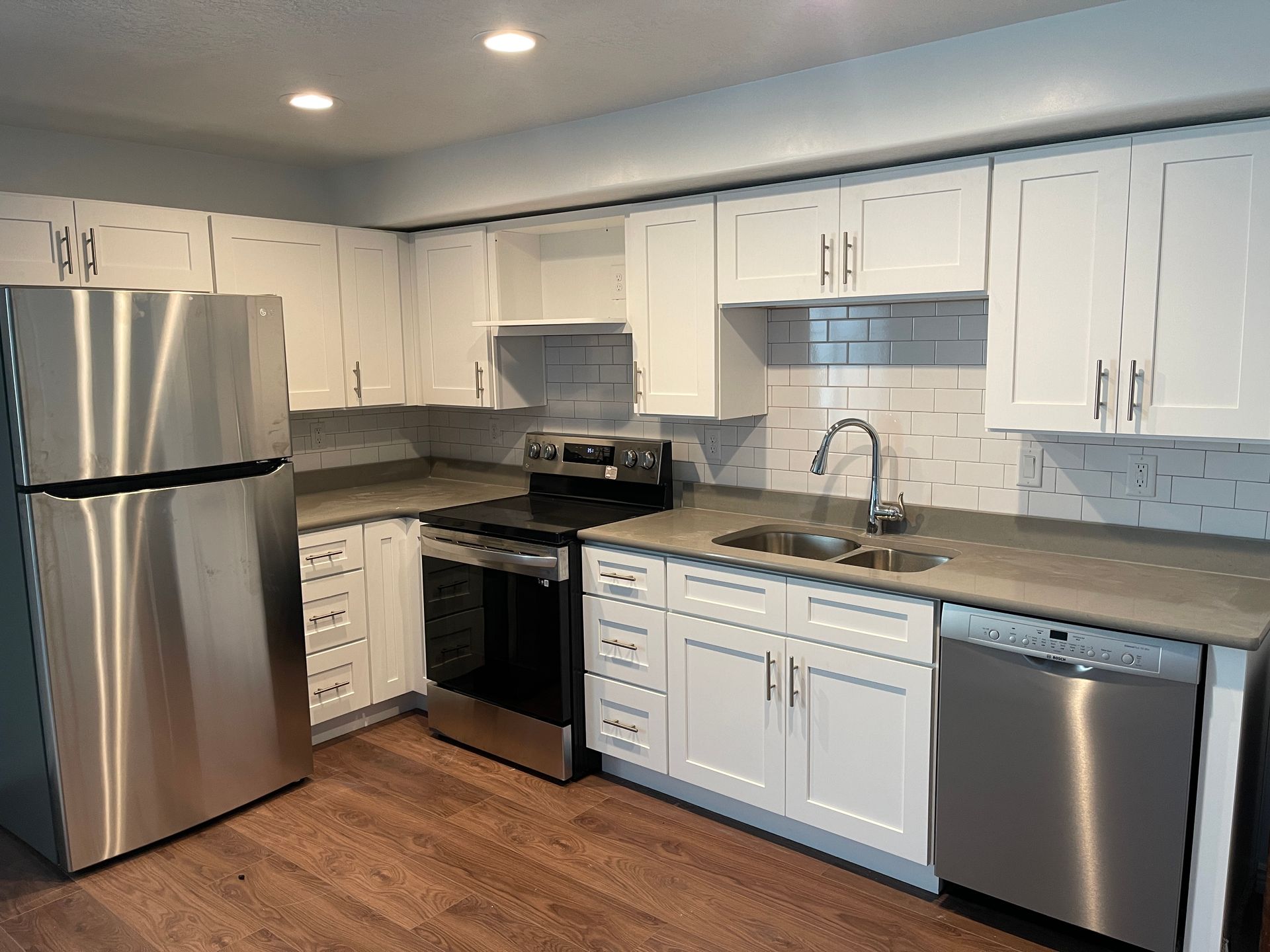 A kitchen with stainless steel appliances and white cabinets.