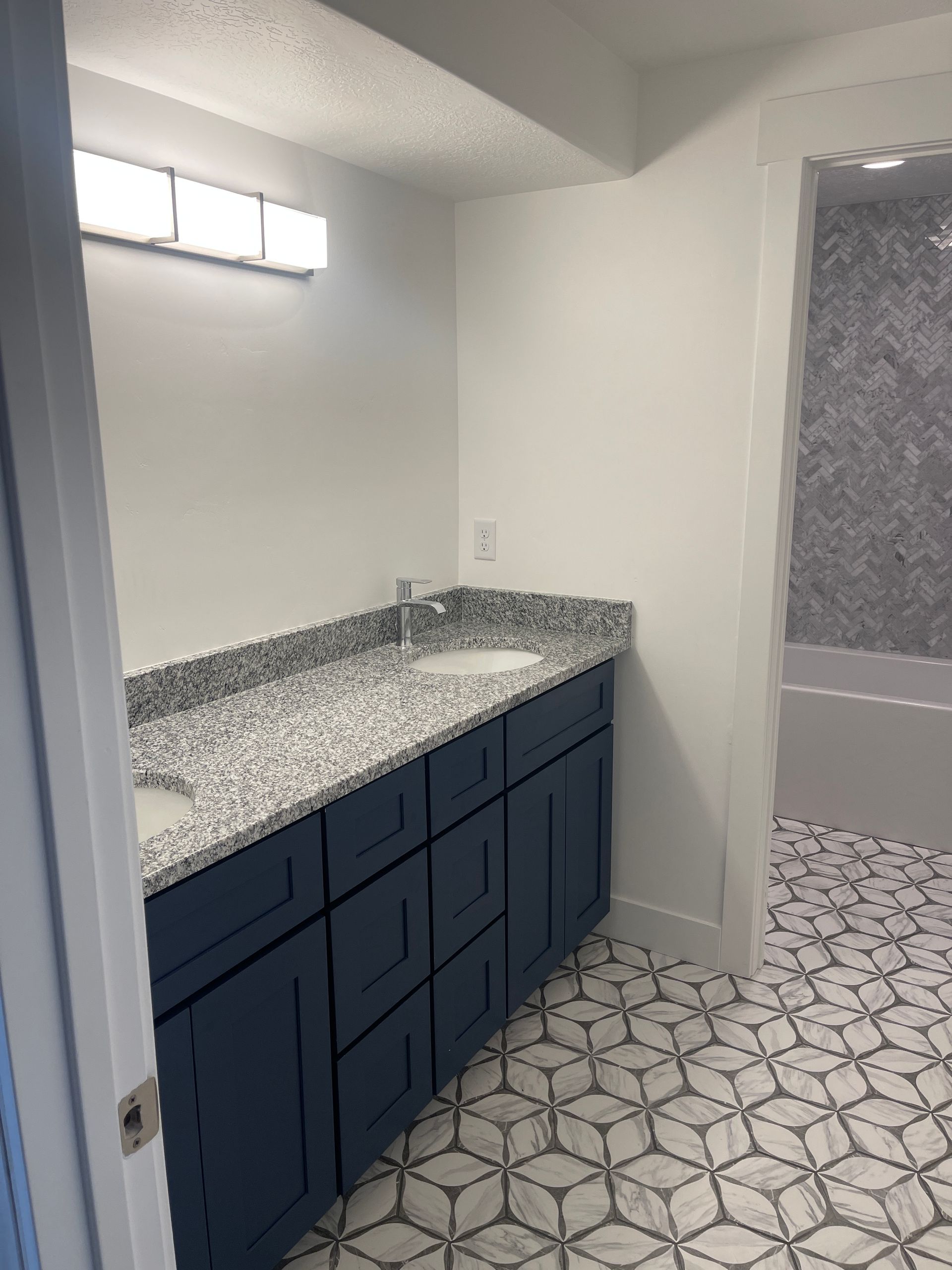 A bathroom with a sink , cabinets , and tile floor.