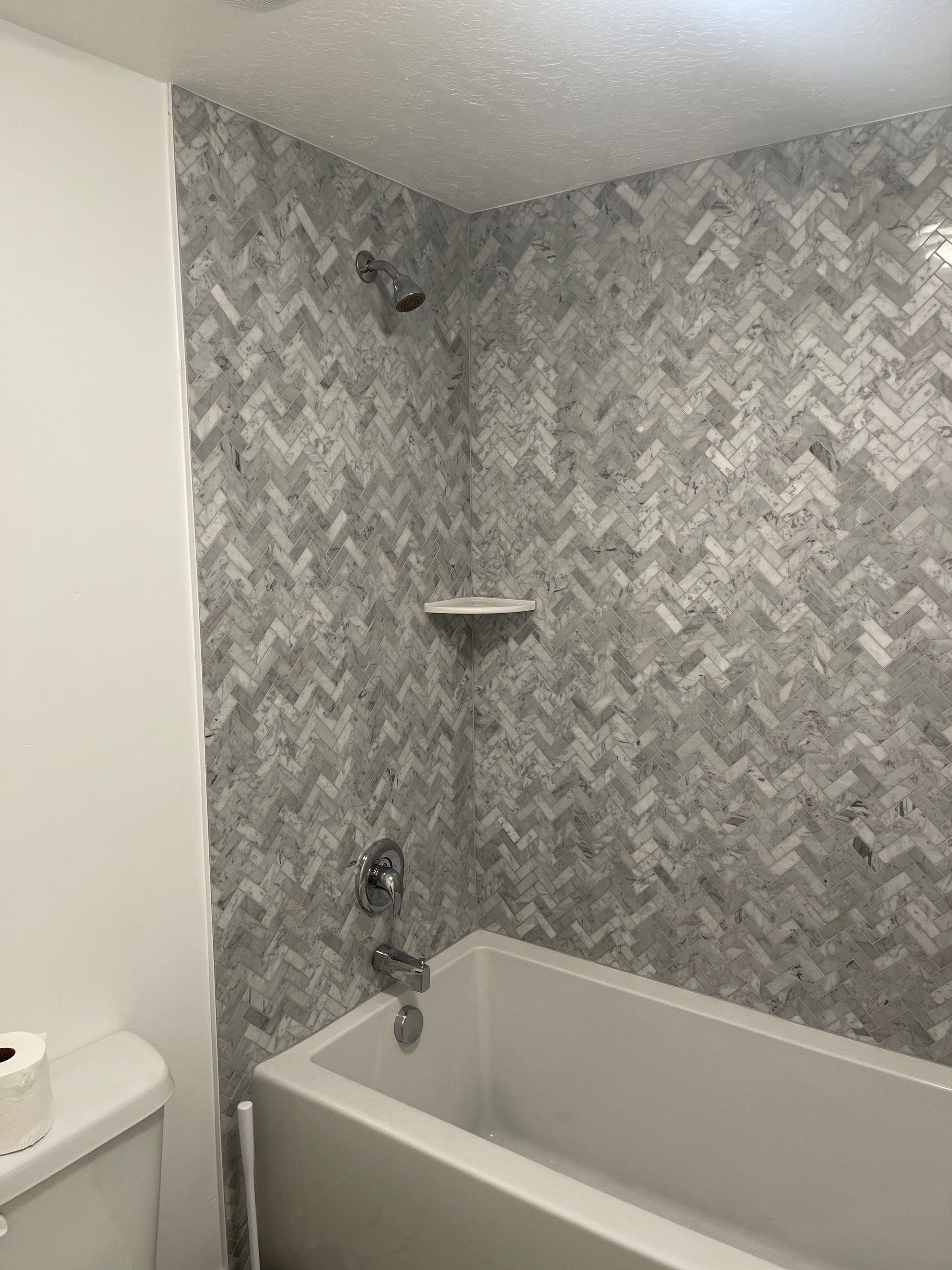 A bathroom with a bathtub , toilet and shower.