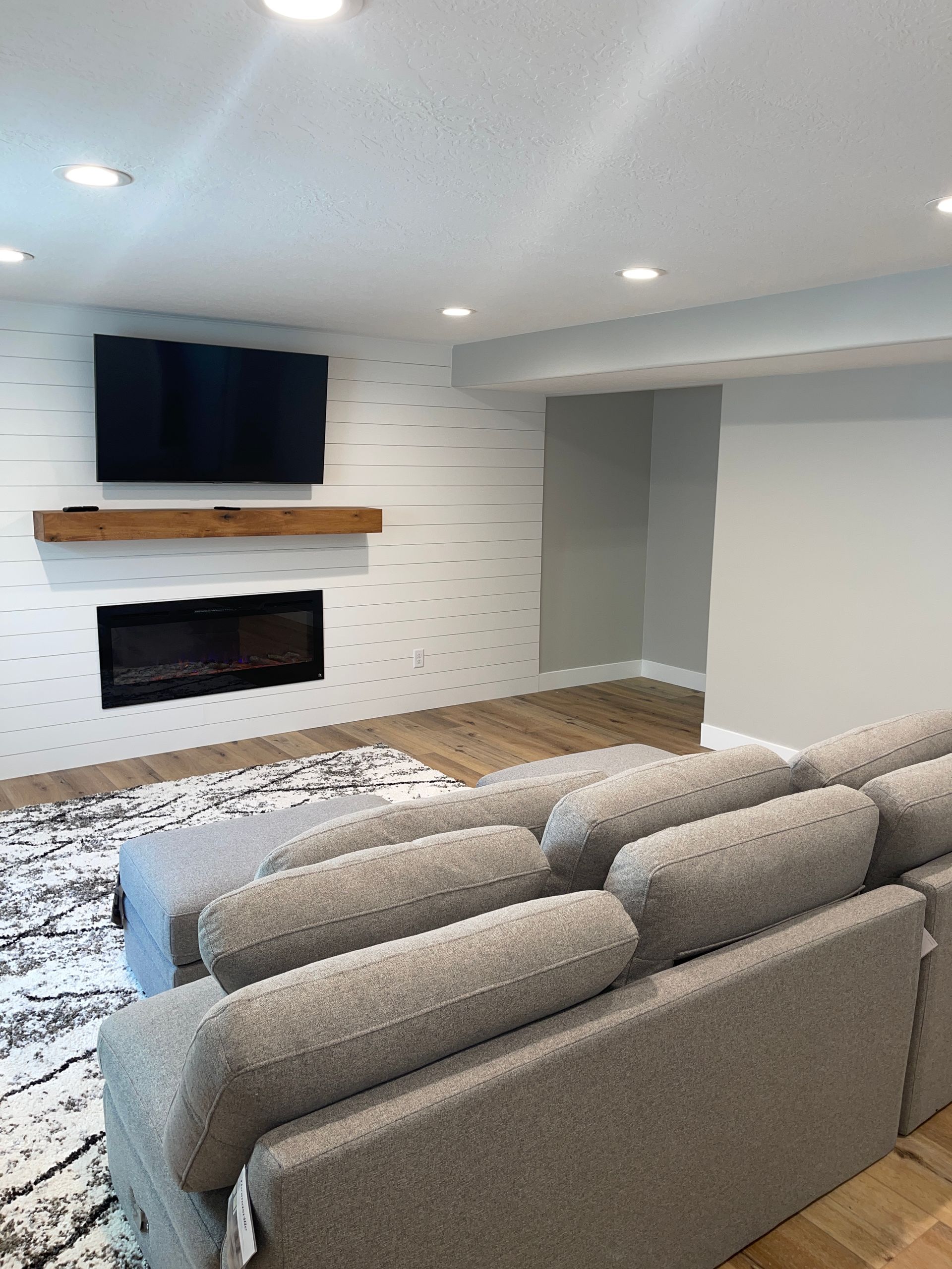 A living room with a couch , fireplace and television.