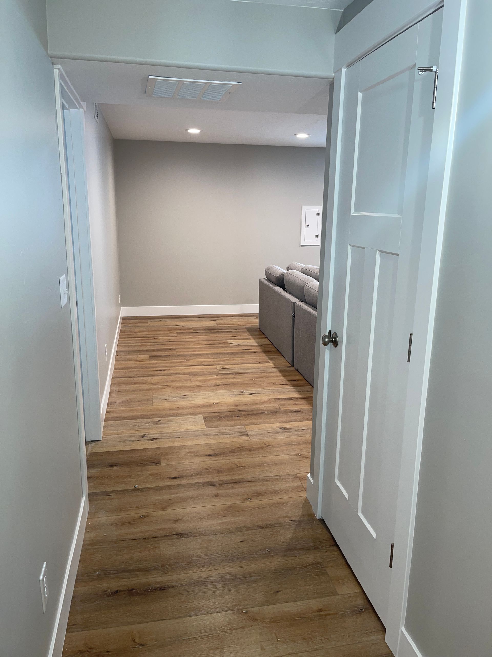 A hallway leading to a living room with a couch