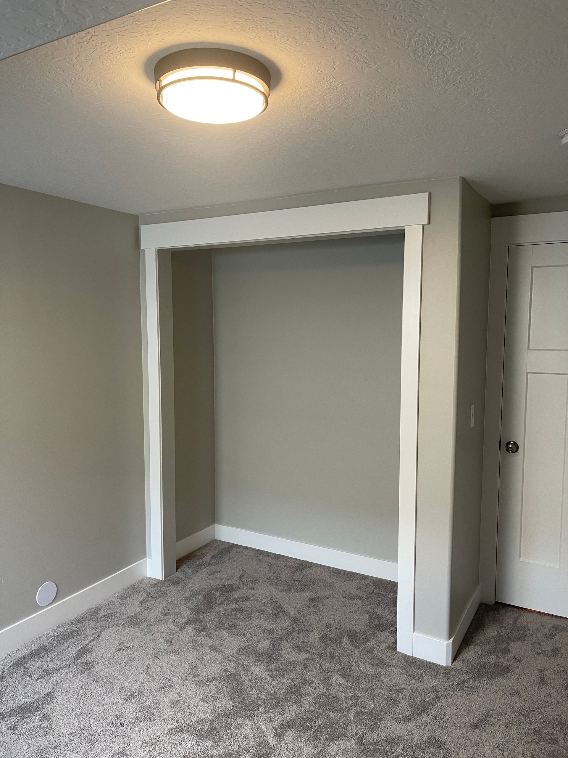 An empty room with a closet and a light on the ceiling.