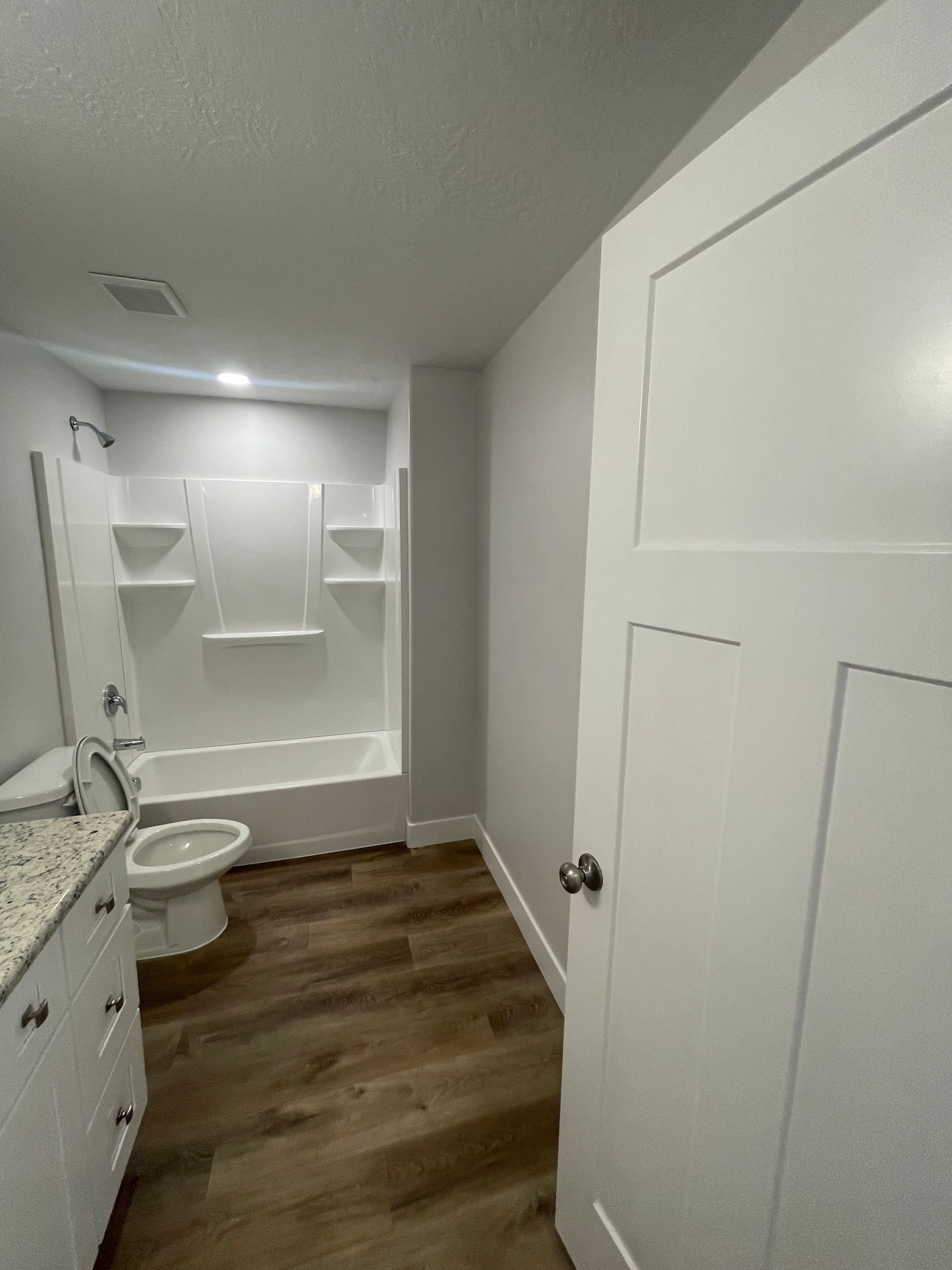 A bathroom with a toilet , sink , bathtub and shower.