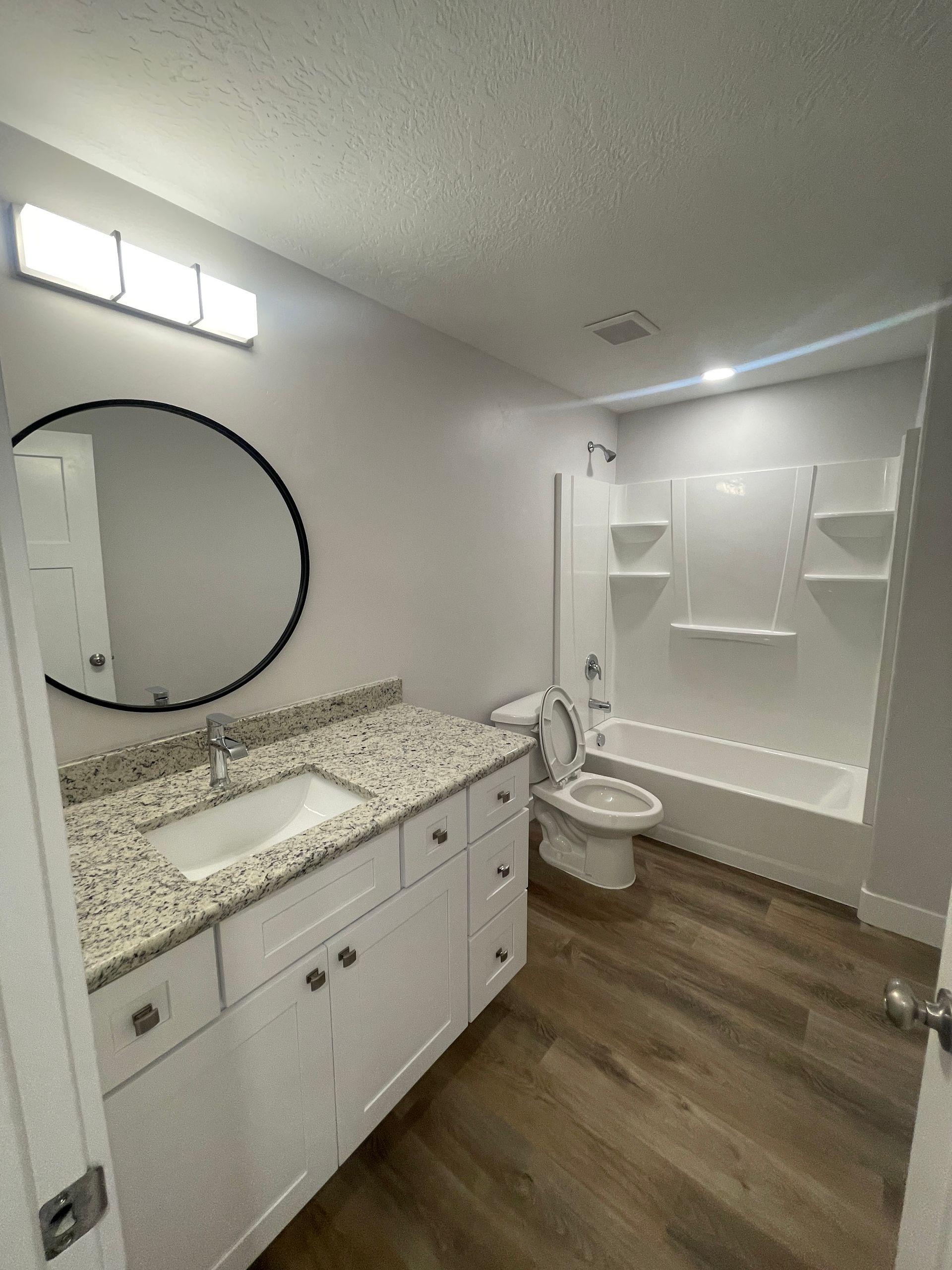 A bathroom with a sink , toilet , bathtub and mirror.