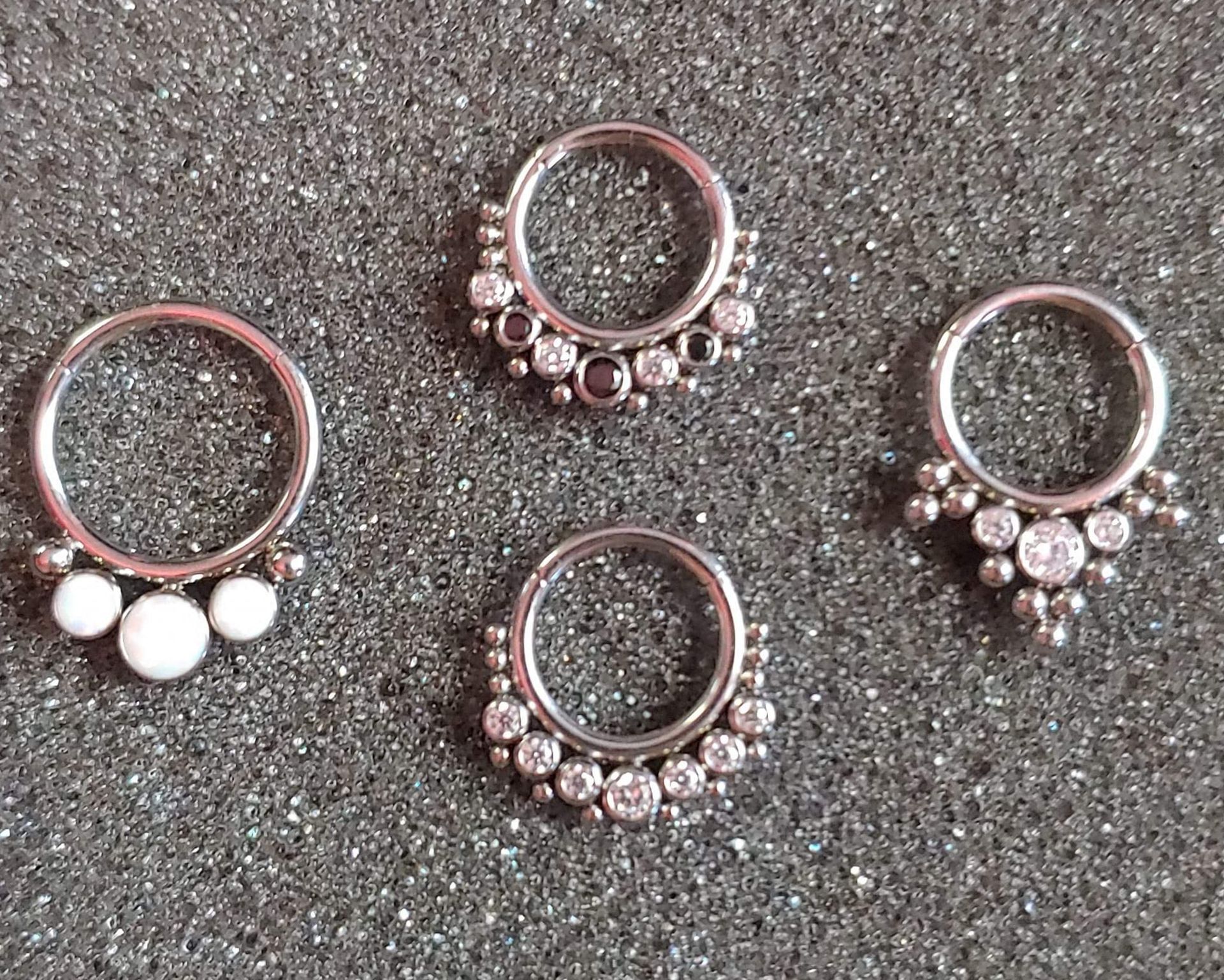 four rings are sitting on a gray surface .