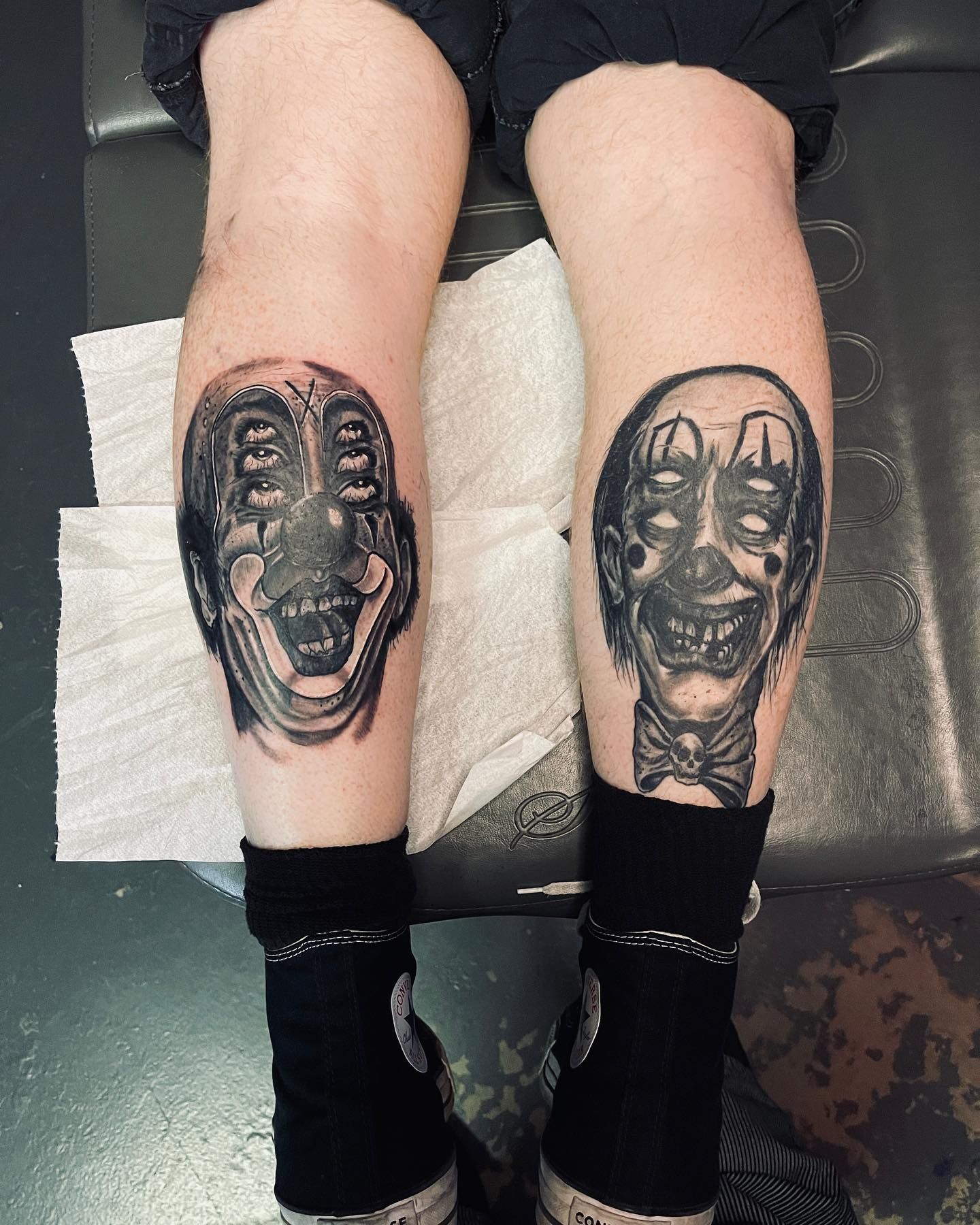 a man and a woman are getting a tattoo in a black and white photo .