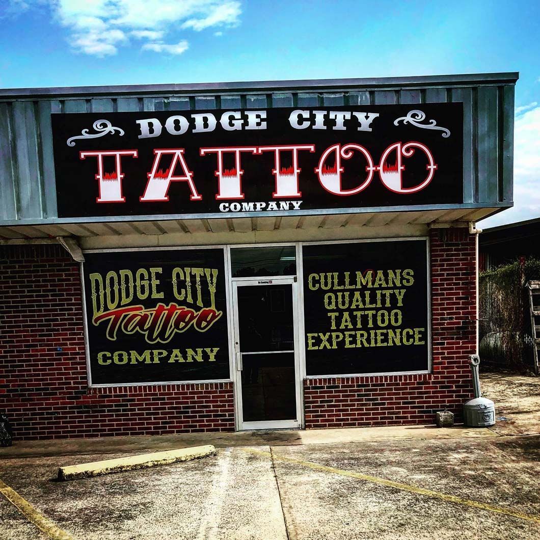 a brick building with a sign that says dodge city tattoo company