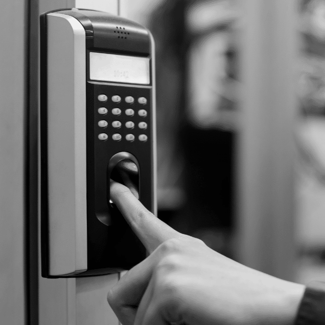 Finger pressing a biometric fingerprint scanner on a keypad access panel