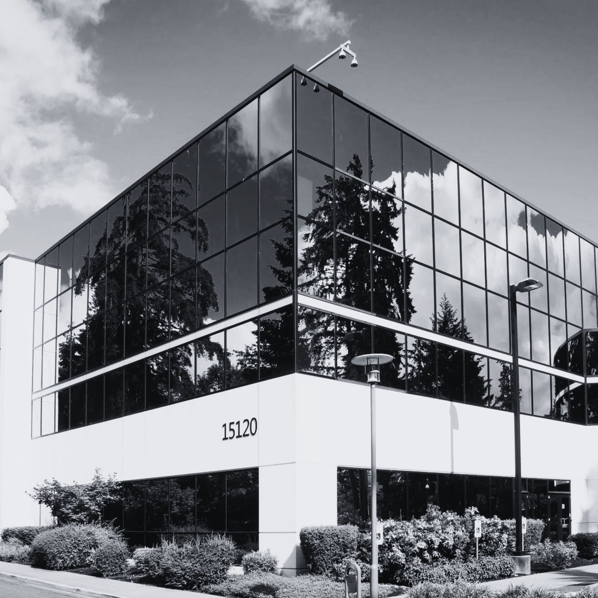 Modern glass office building with reflective windows and landscaping