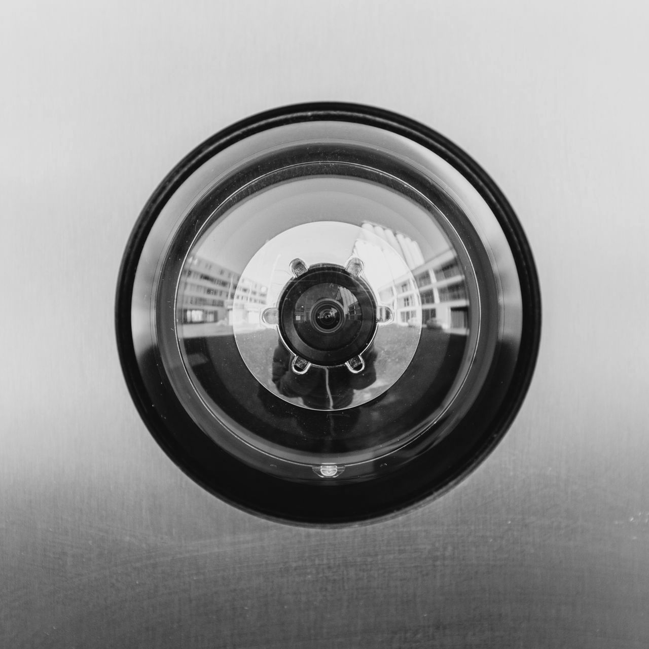 Black circular lens or camera lens centered on a brushed metal surface.