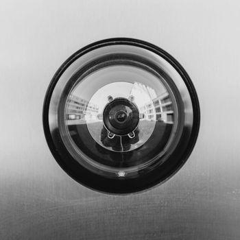 Close-up of a circular camera lens or door peephole on a metallic surface
