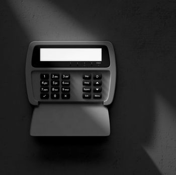 Black biometric keypad device with blank display and covered scanner on a dark background