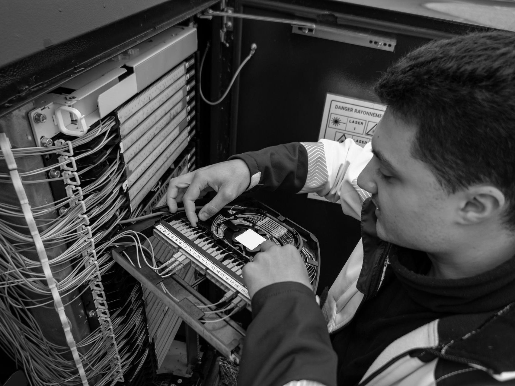 Technician connecting cables inside an open computer server rack