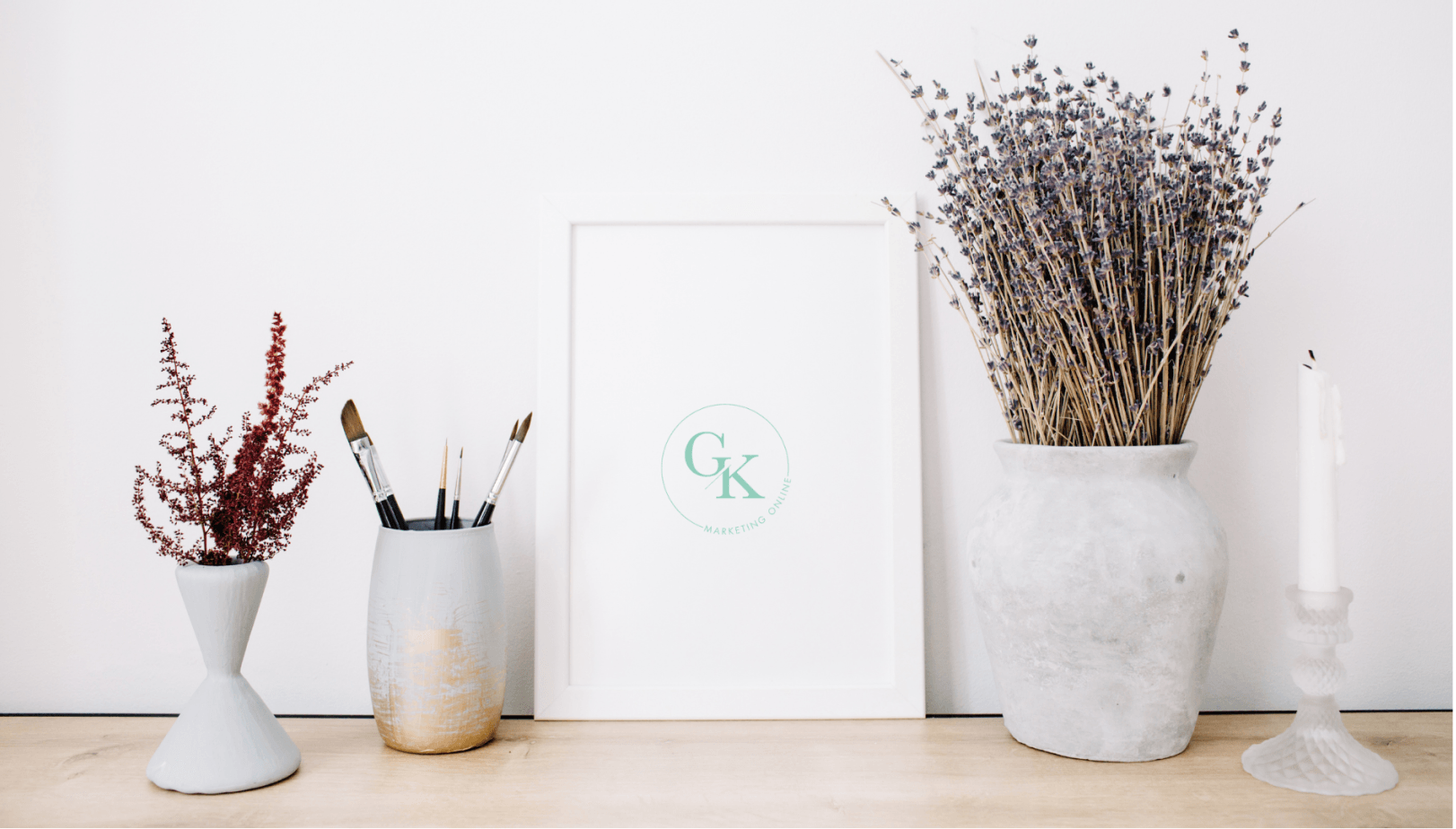 GK Marketing Online | A table with a picture , vases , candles and brushes on it.