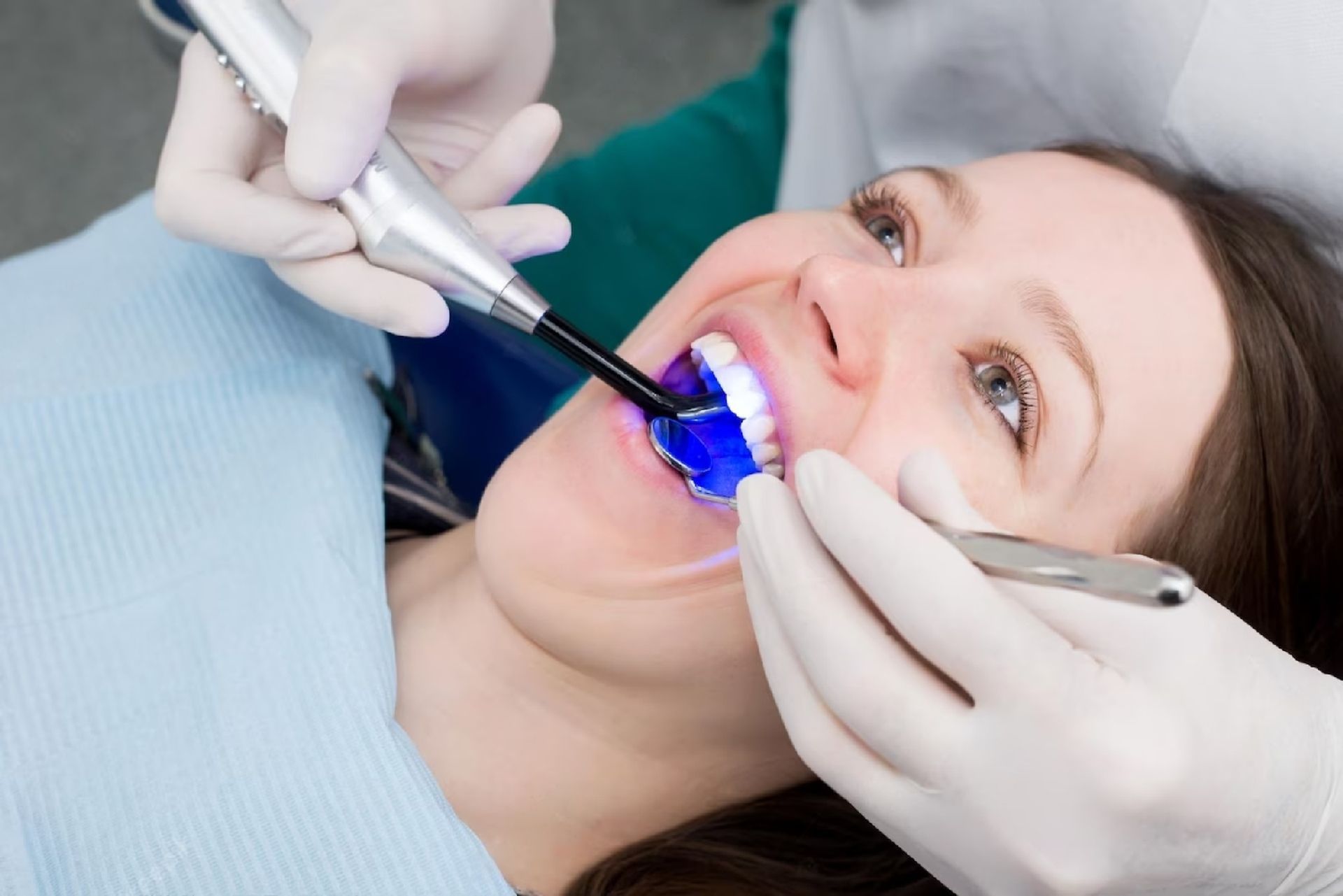 Woman with a bright smile | Visit the best dentist in Oak Point 75068. A woman is getting her teeth examined by a dentist