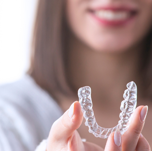 A woman is holding a clear brace in her hands.