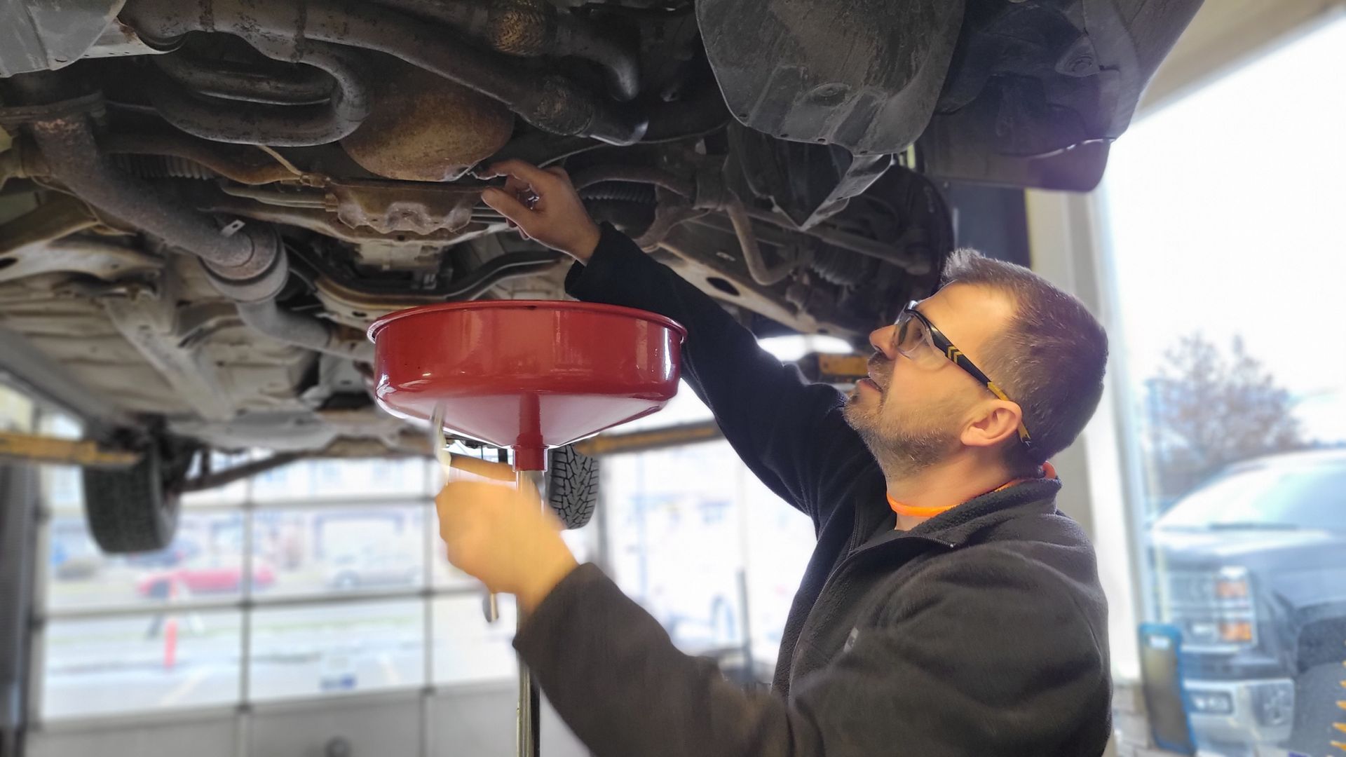 A close-up of a Lakeshore Automotive technician inspecting the oil of a customer vehicle.