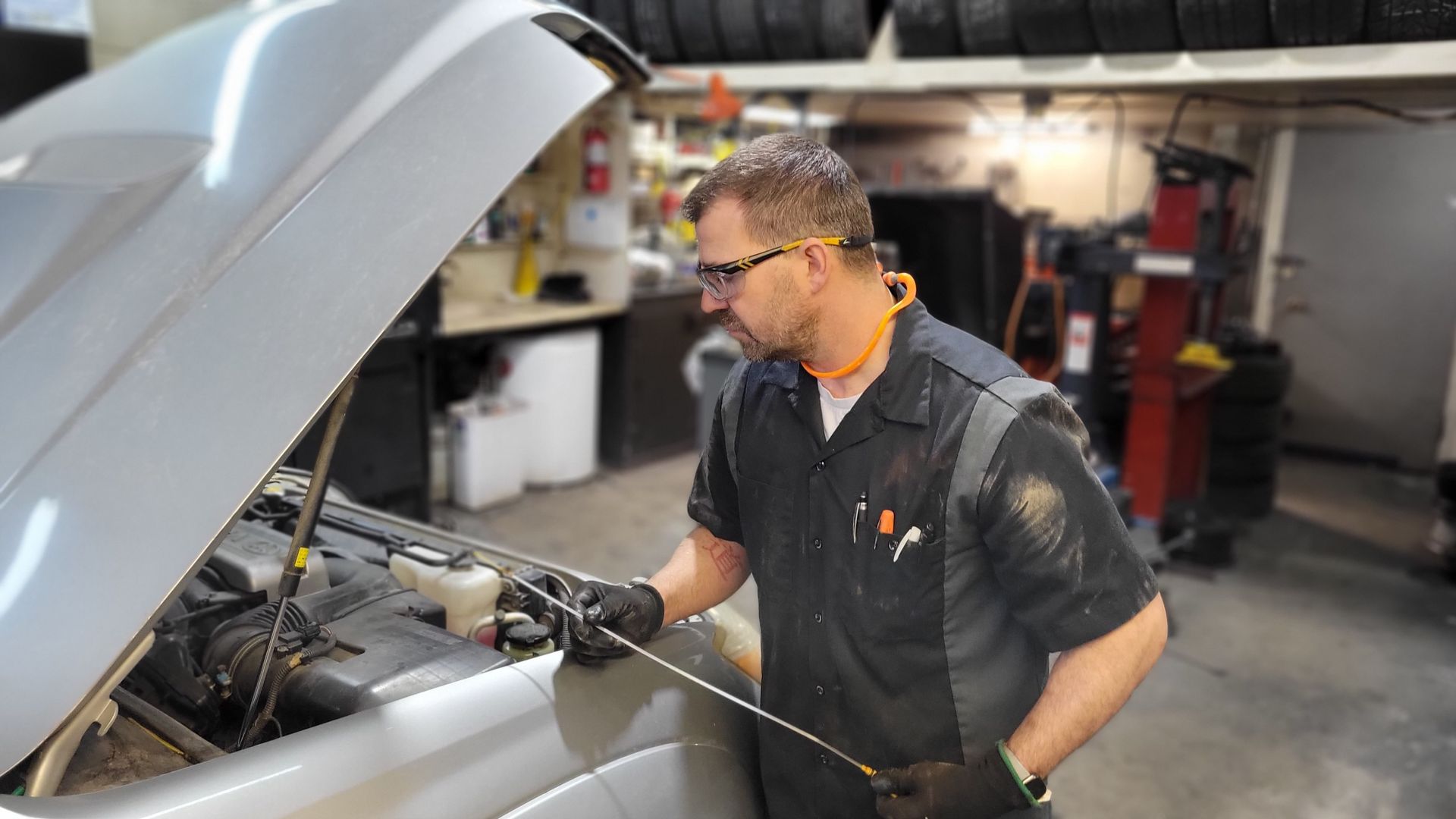 A close-up of a Lakeshore Automotive technician inspecting the tires on a customers vehicle.