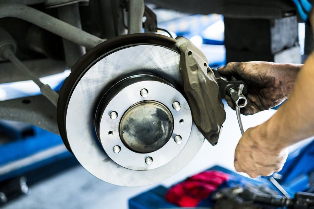 A Person Is Working on A Motorcycle with A Wrench — Coastal Mechanical Solutions In Albion Park Rail, NSW