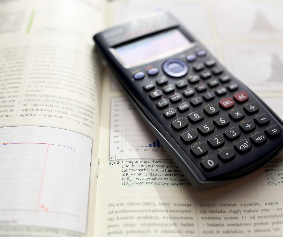 Calculator on an open textbook with printed text and graphs.