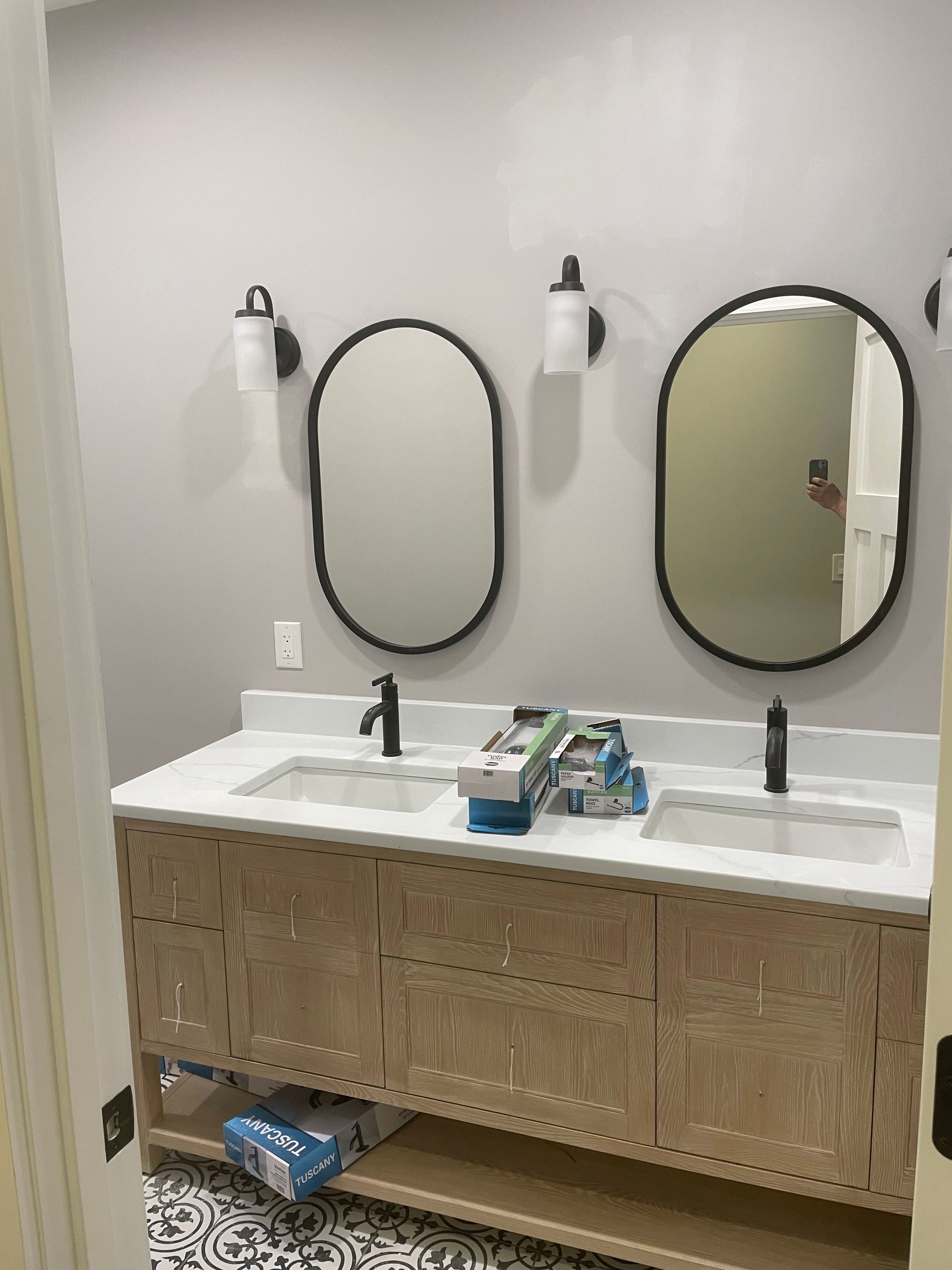 Double sink vanity with mirrors and soap dispensers in a restroom or bathroom.