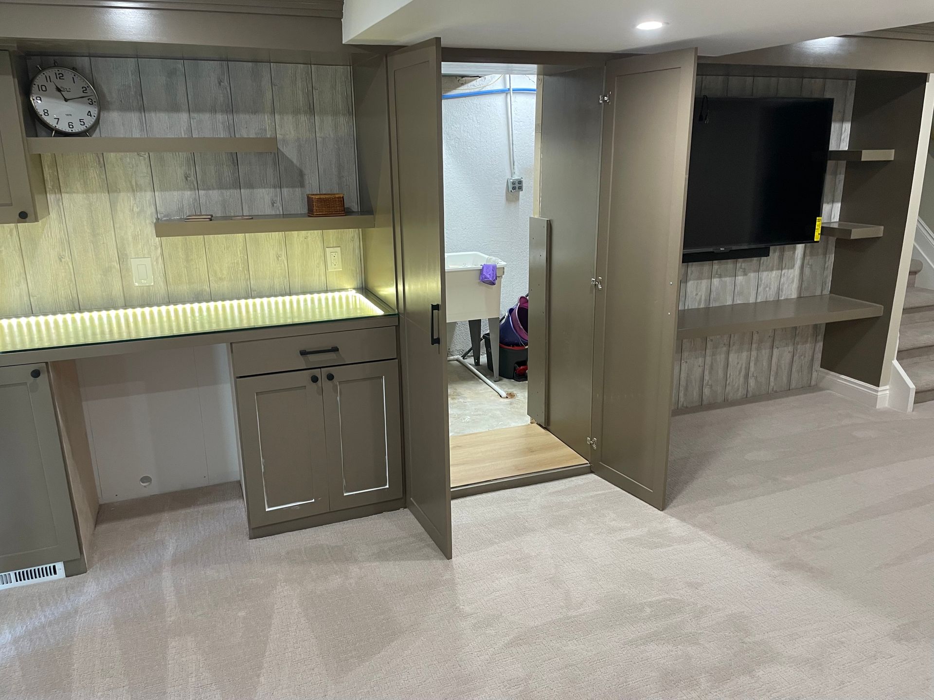 Modern kitchen with built-in cabinets, sink area, and open doorway to a tiled room