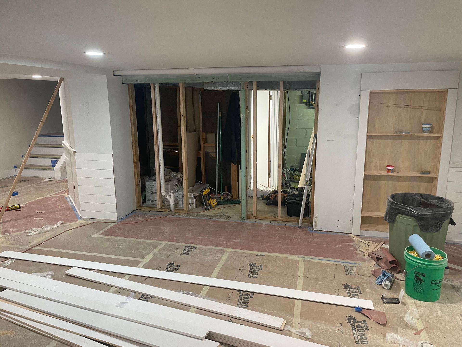 Home renovation room with exposed wall framing, construction materials, and tools on the floor