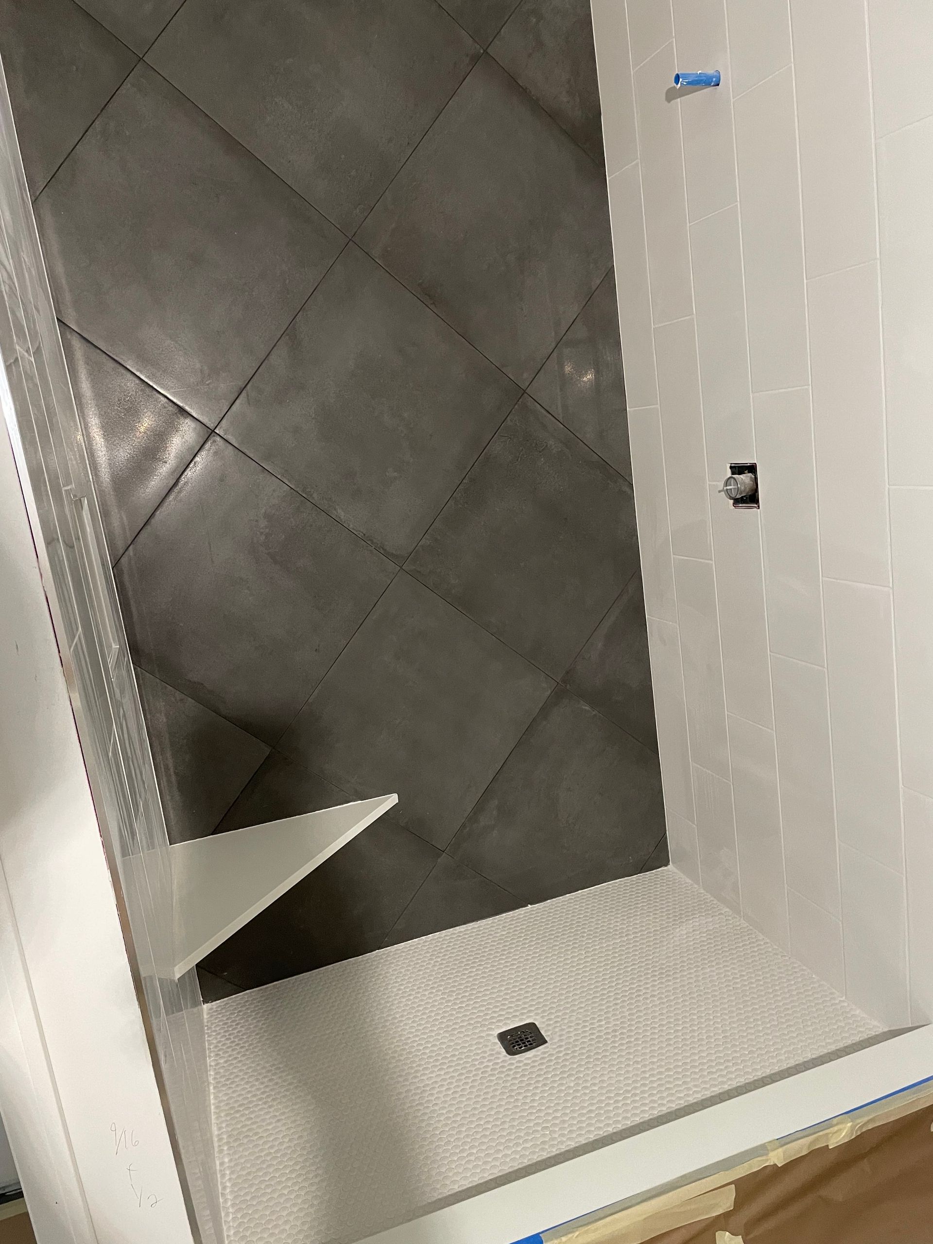 Empty white cabinet interior with a dark quilted panel and a small shelf or bracket inside.