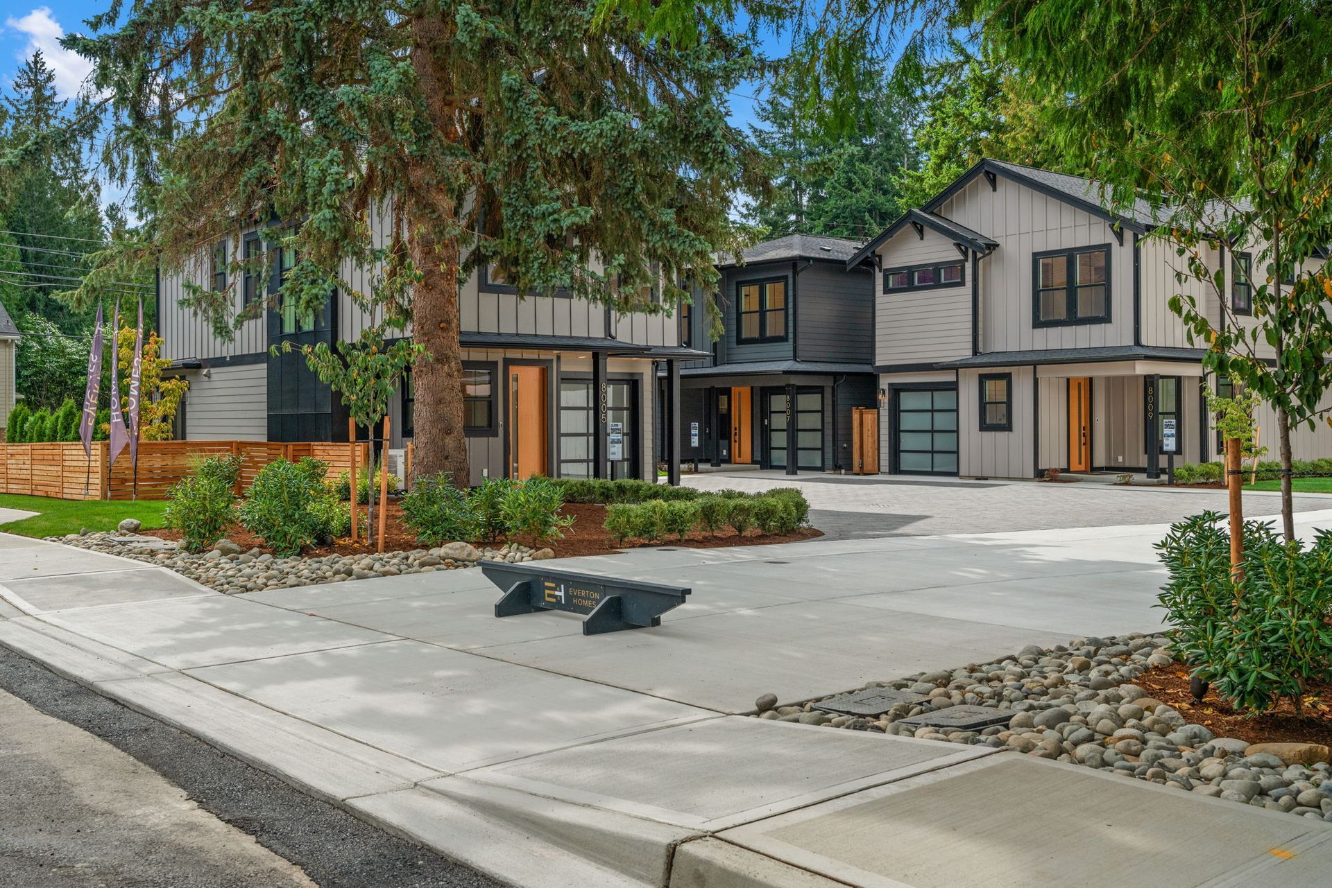 Backyard of a modern home with patio furniture, a small lawn, and a wooden fence.