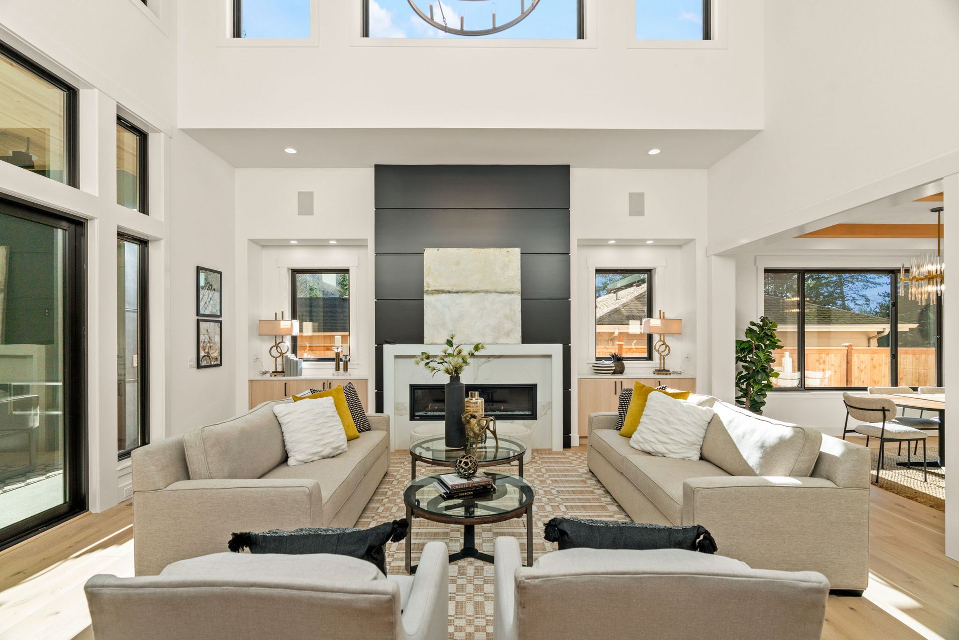 Living room with high ceilings, two couches, fireplace, and black accent wall.