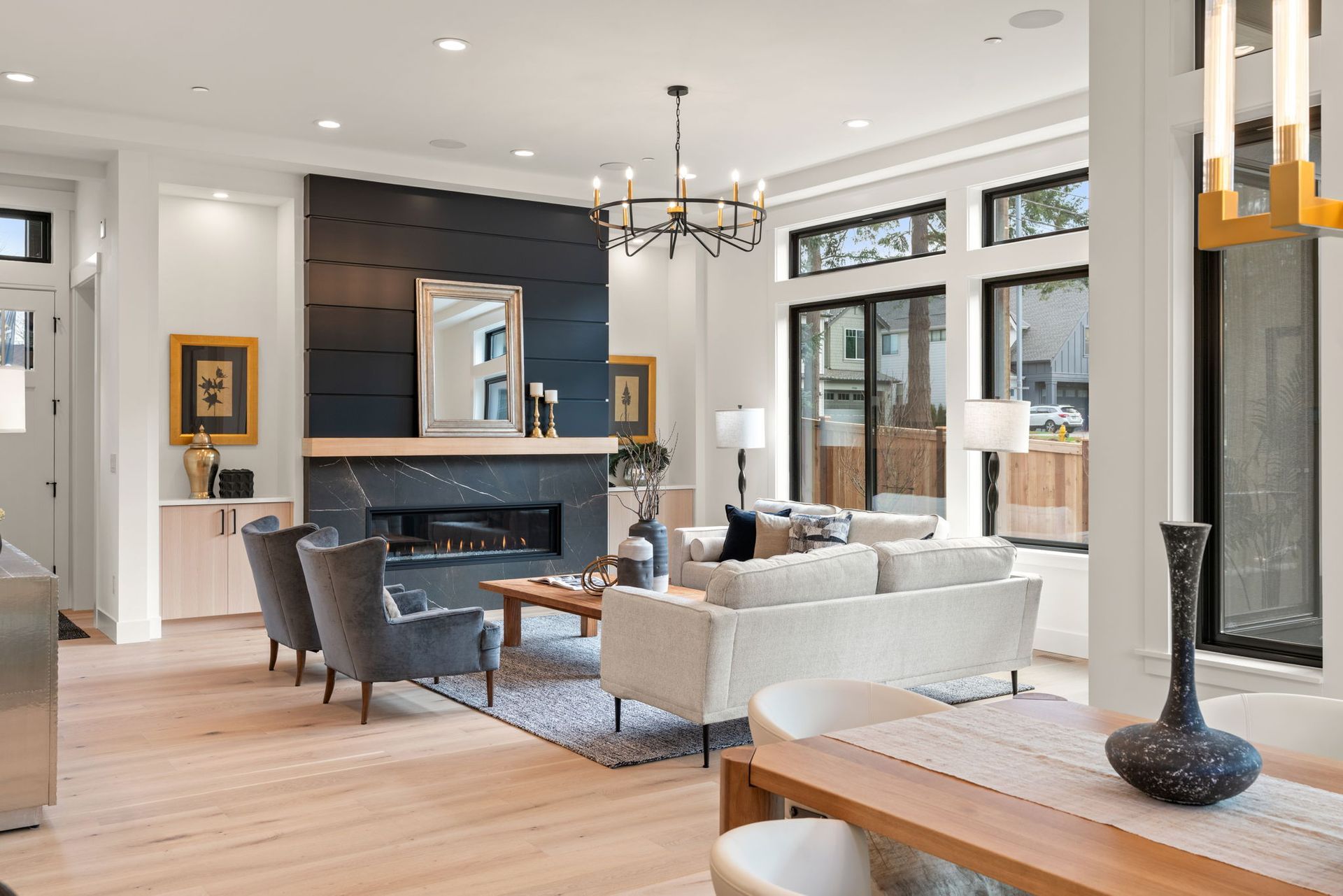 Living room with fireplace, white walls, light wood floors, and modern furniture.