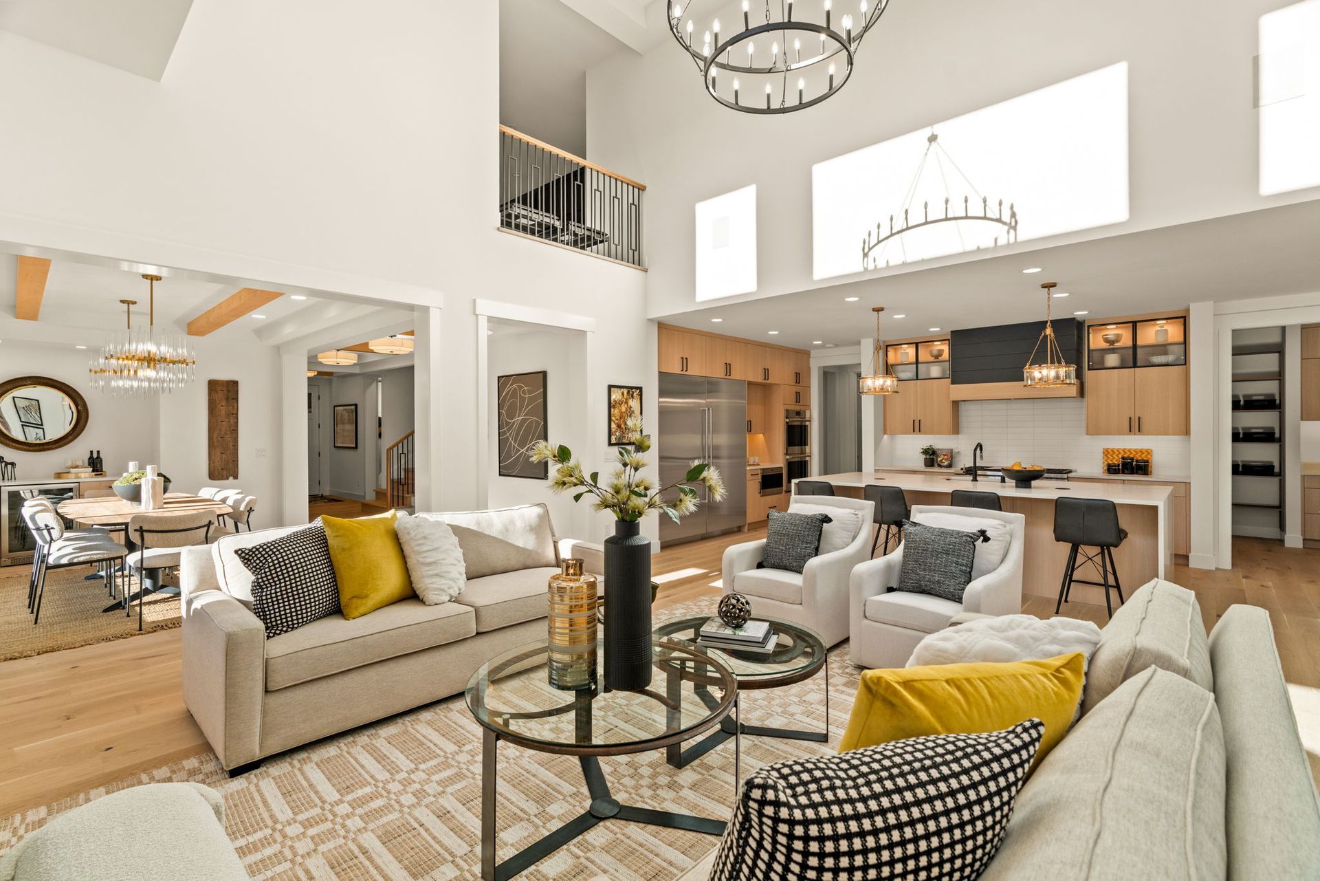 Spacious, modern living area with high ceilings, open kitchen, and neutral tones.