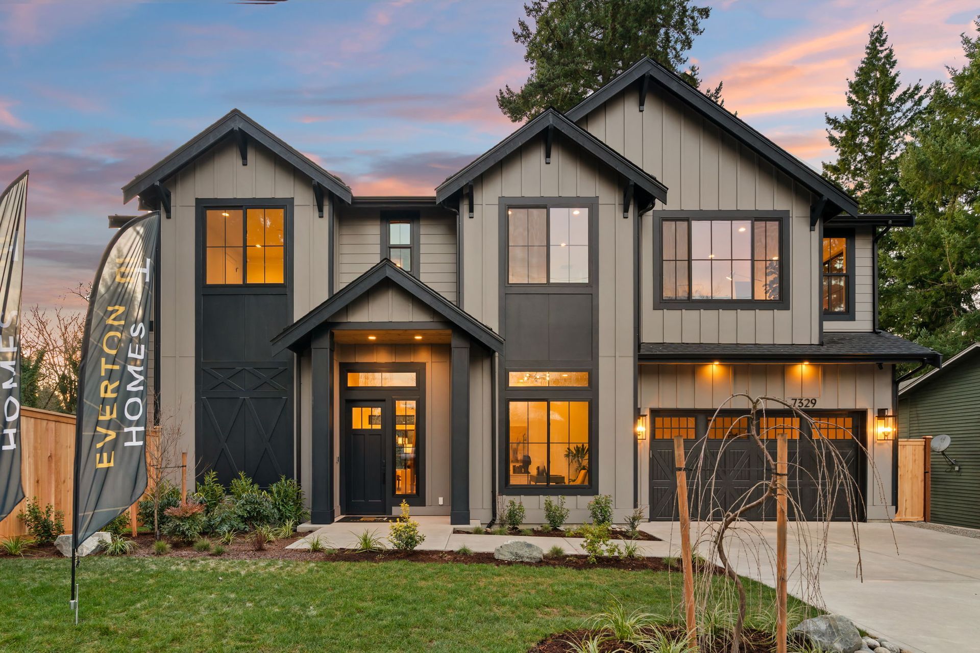 Two-story modern home with gray siding, black trim, and a lawn. Everton Homes sign in front.