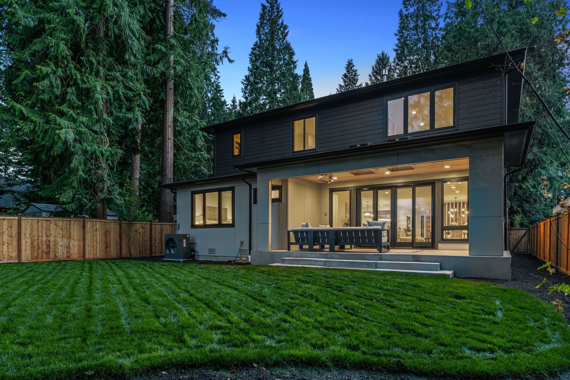 The back of a house with a spacious patio a large lawn.