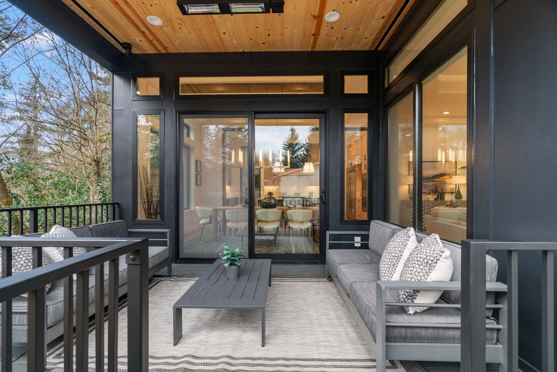 Outdoor patio with gray furniture, rug, and sliding glass doors.