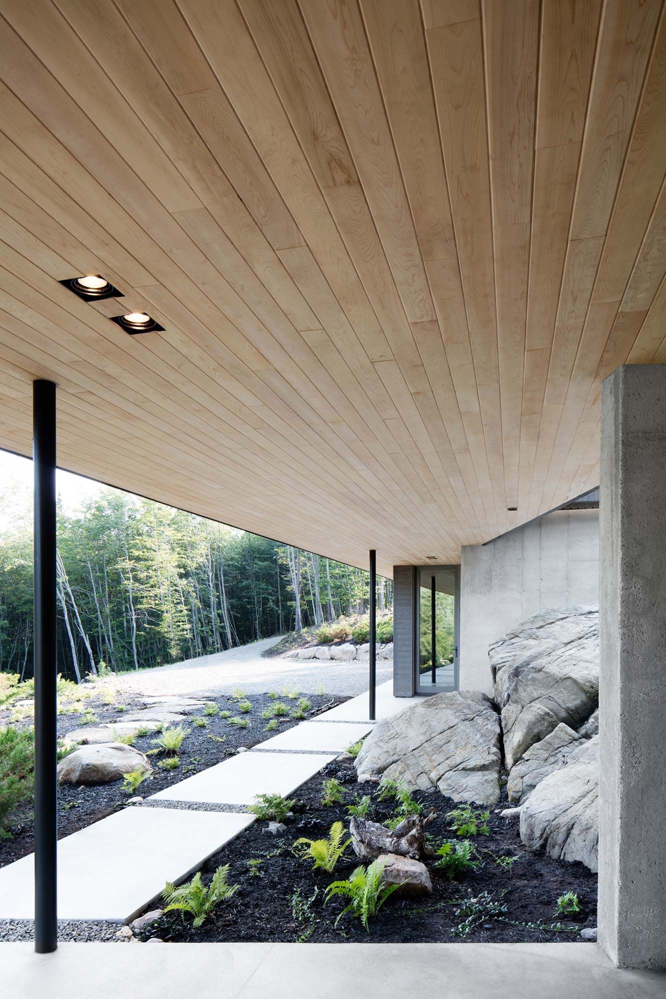 A house with a wooden ceiling and a walkway leading to it.