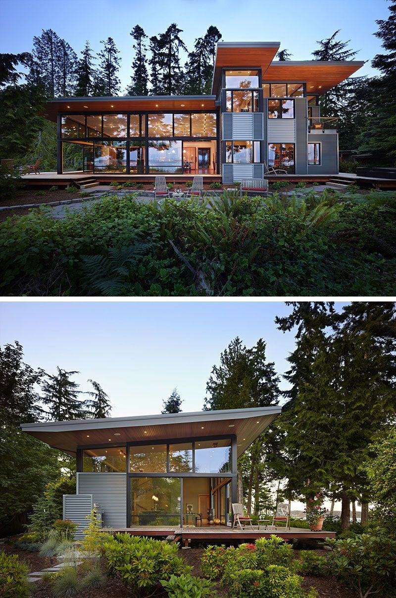 A house with a lot of windows is surrounded by trees