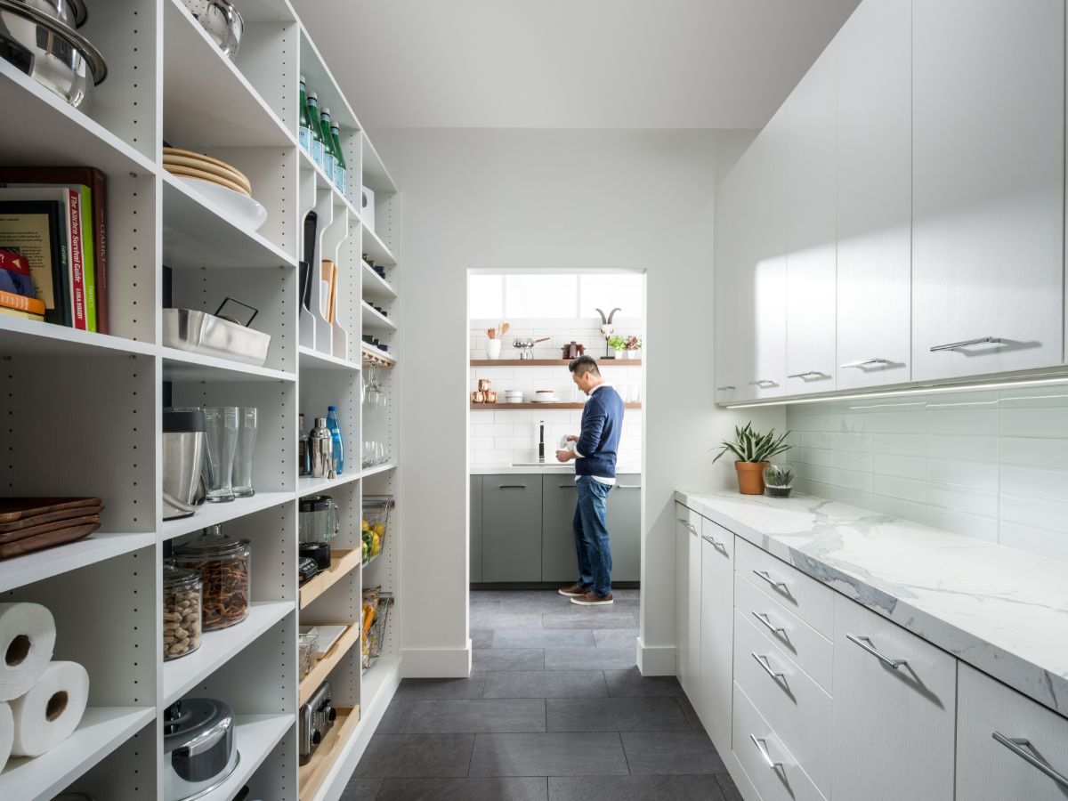 A man is standing in a kitchen looking at his phone.