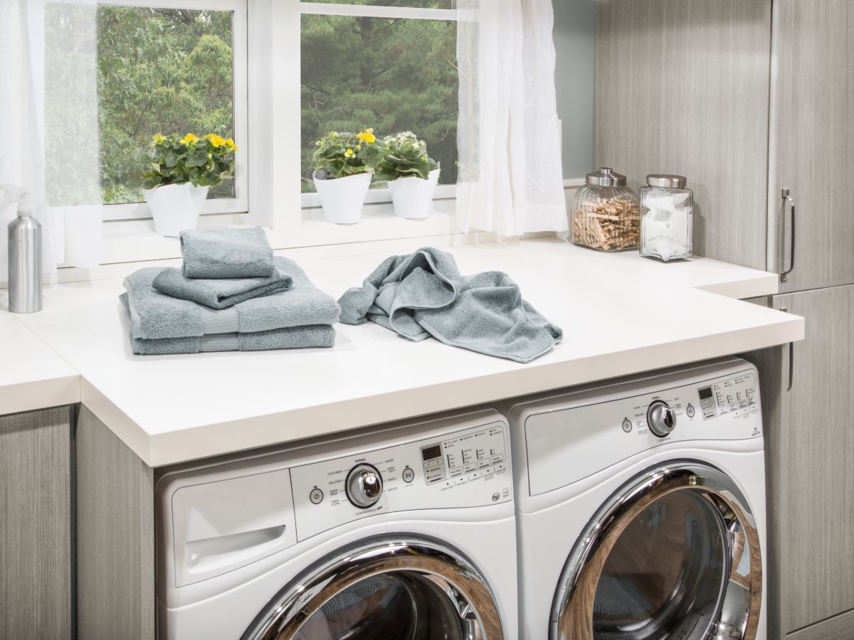 A laundry room with a washer and dryer and towels on the counter.