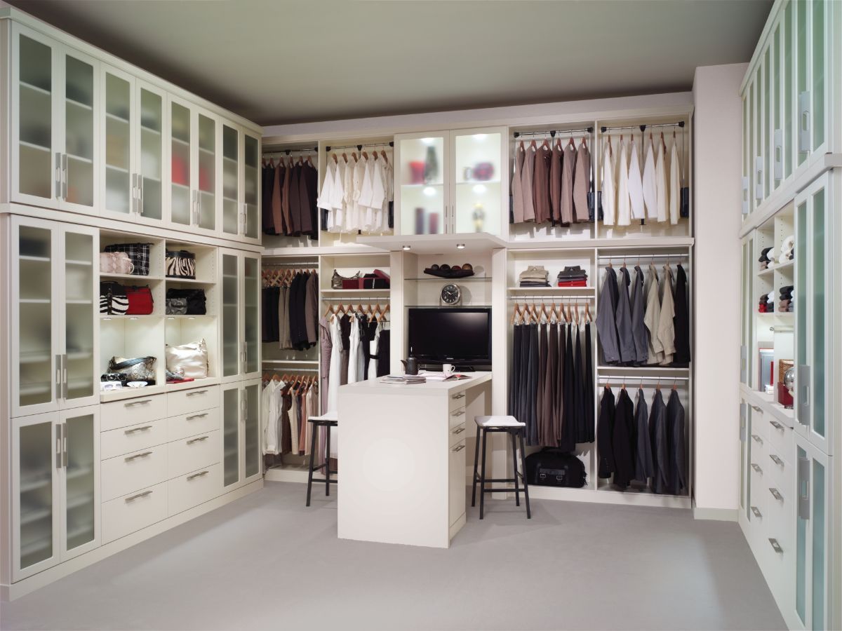 A walk in closet with lots of clothes and a tv