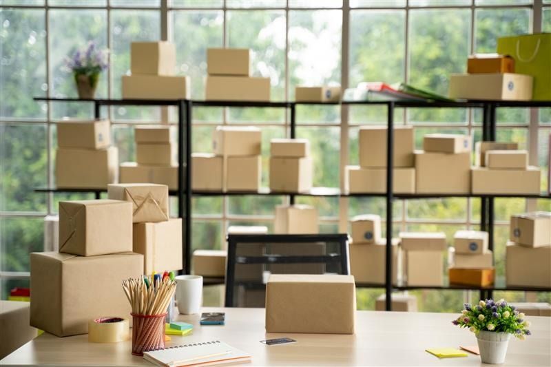 Mini storage space with shelves filled with cardboard boxes and packages.