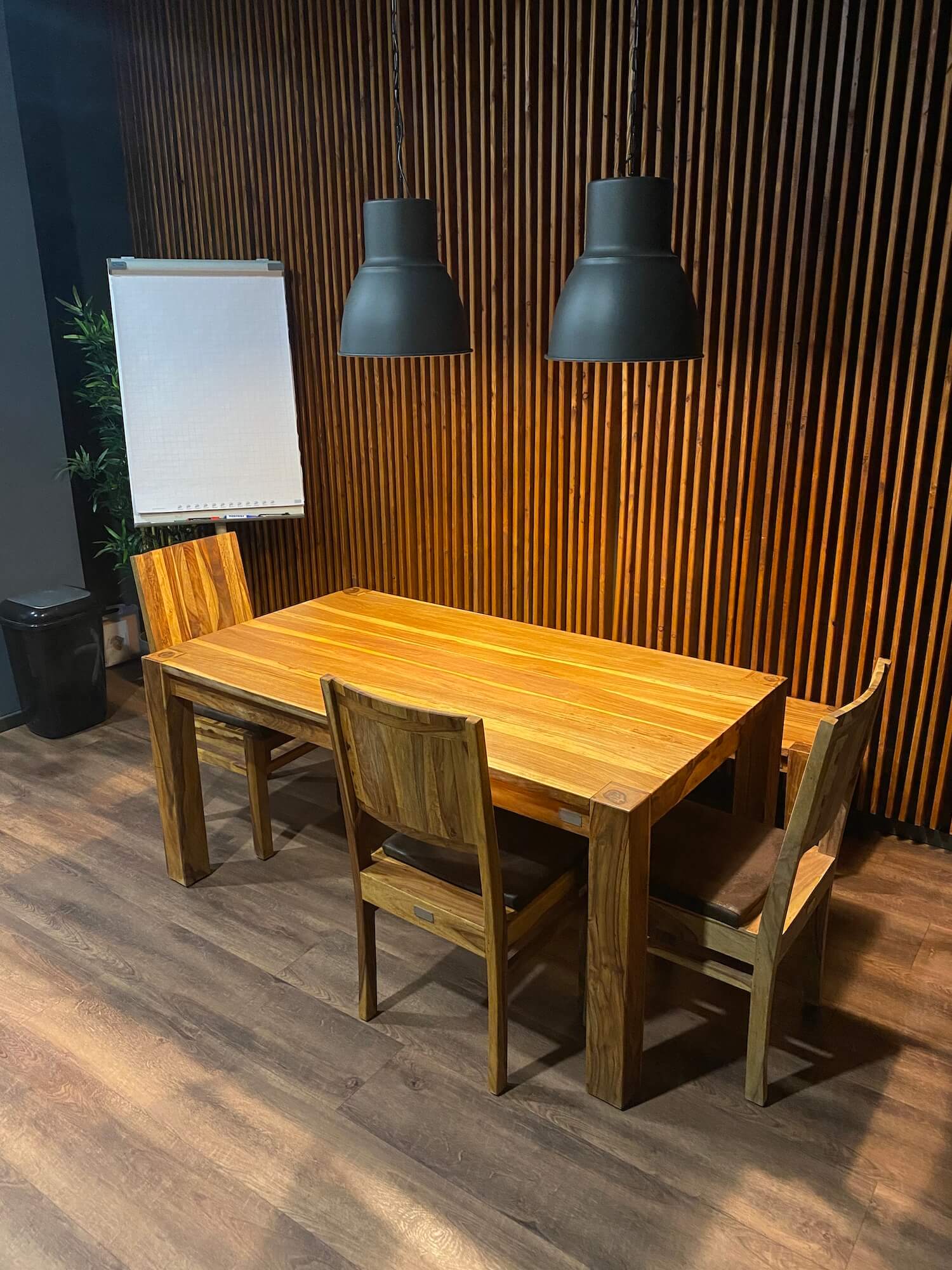 Ein Holztisch und Stühle in einem Raum mit einer Holzwand.