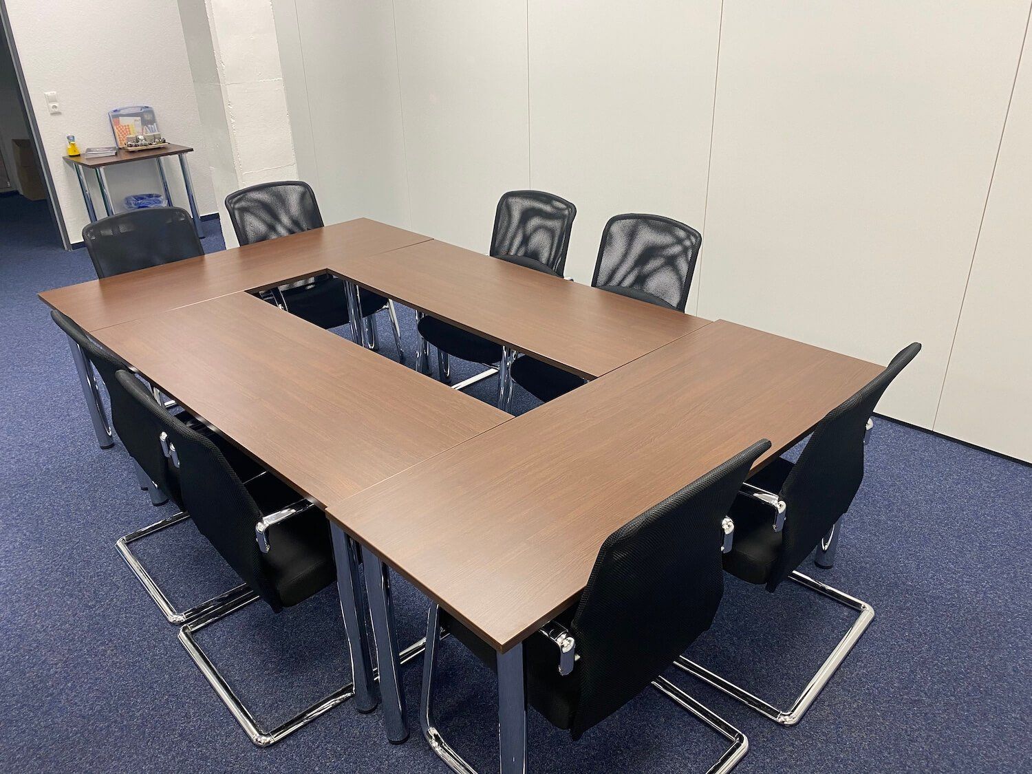 Ein Konferenzraum mit einem langen Tisch und Stühlen.