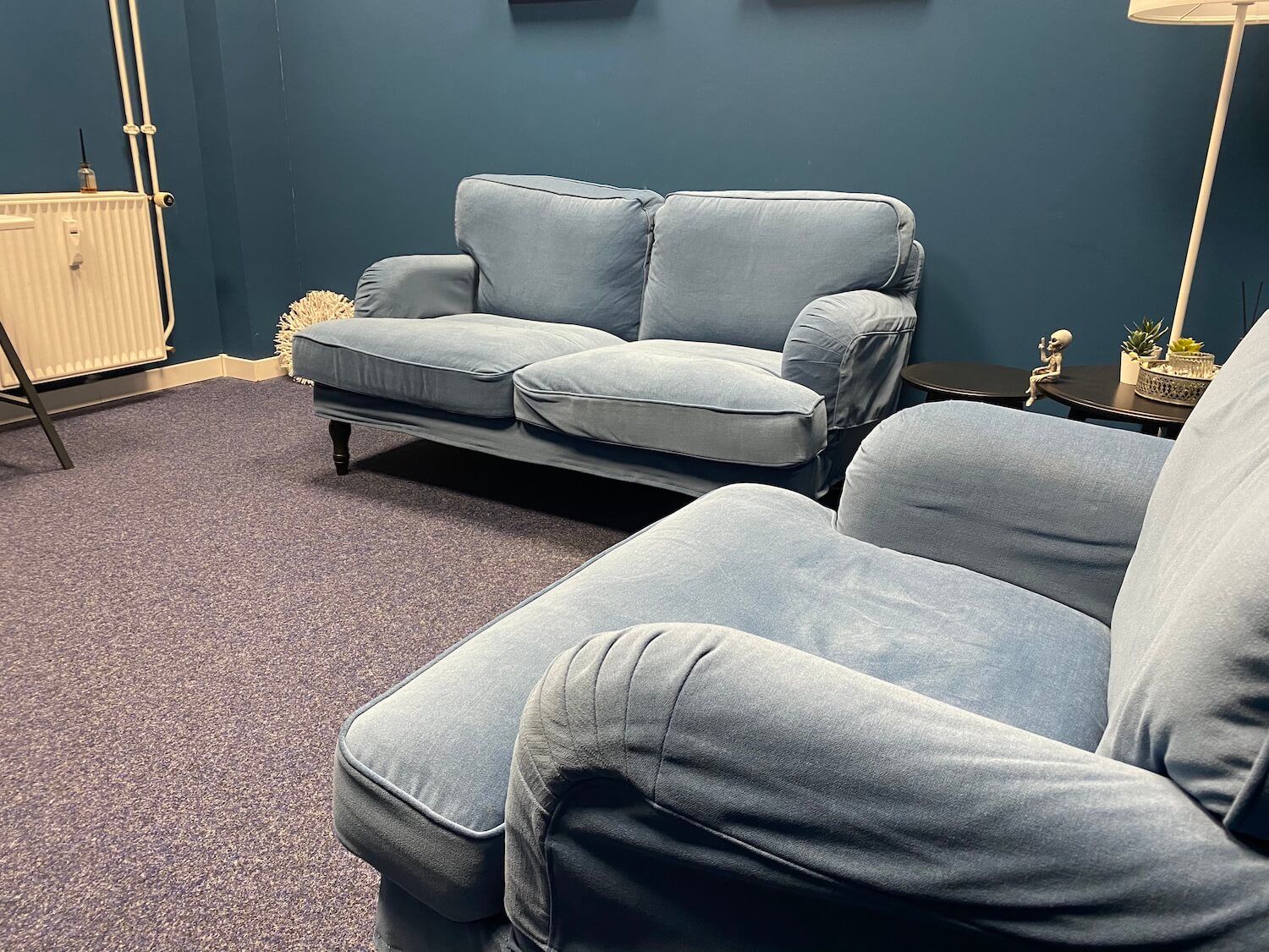 Im Zimmer befinden sich eine Couch und zwei Sessel.