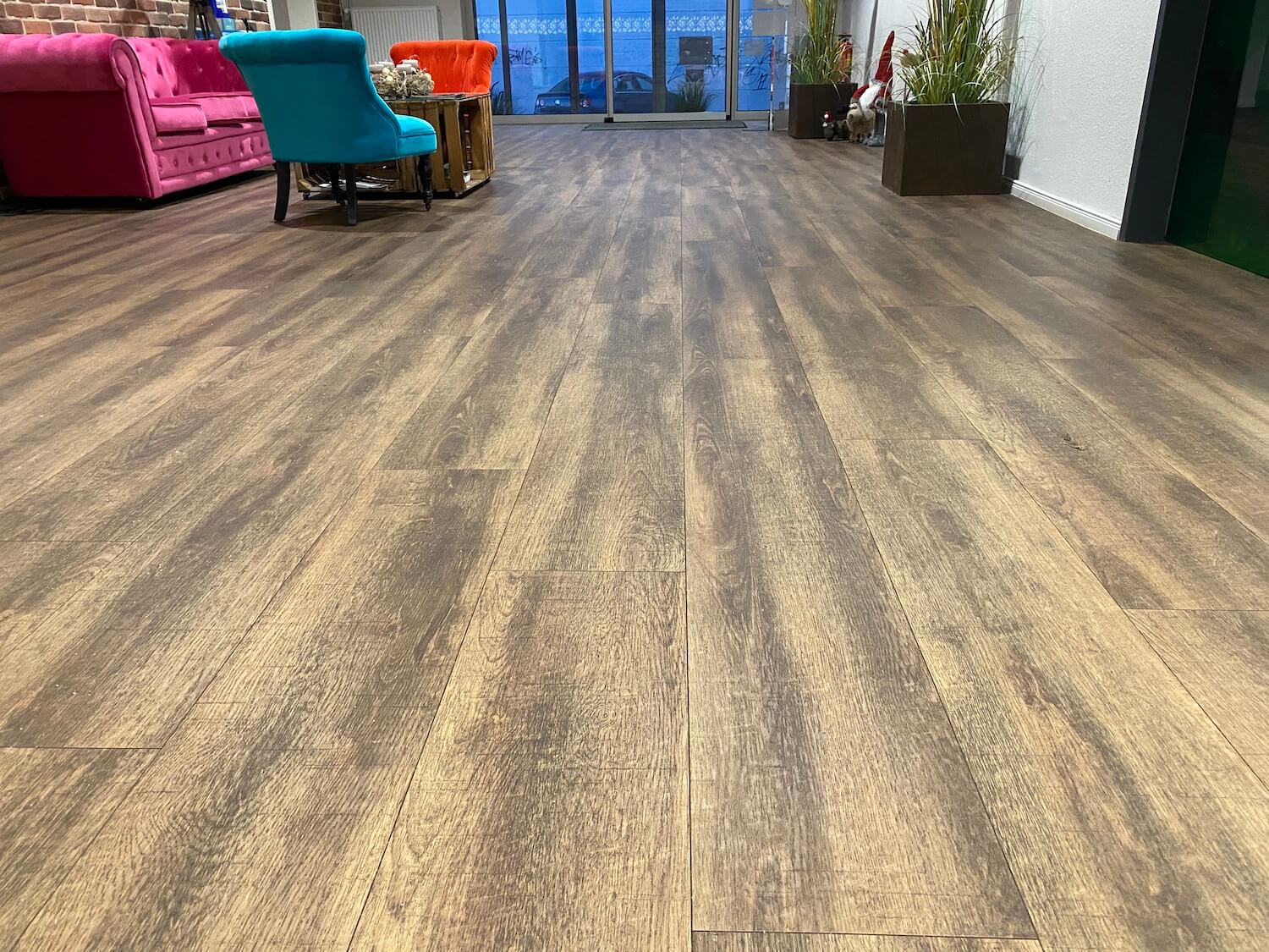 Ein Wohnzimmer mit Holzboden und farbenfrohen Möbeln.