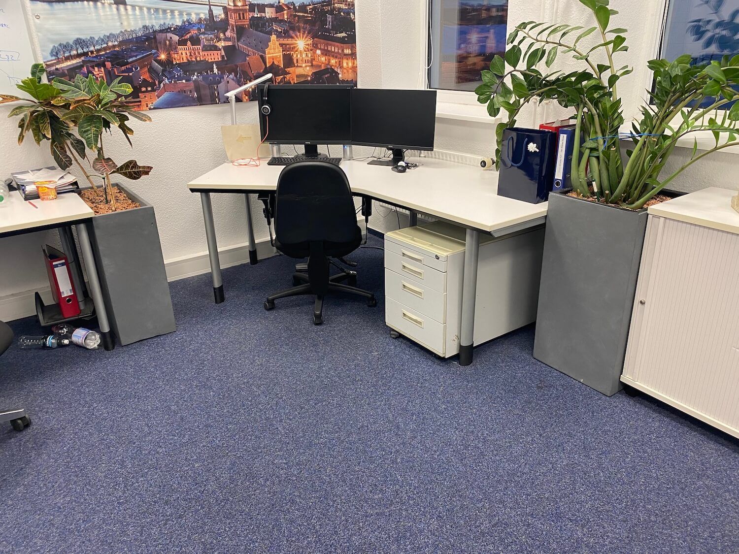 Ein Schreibtisch mit einem Computer und einem Stuhl in einem Büro.
